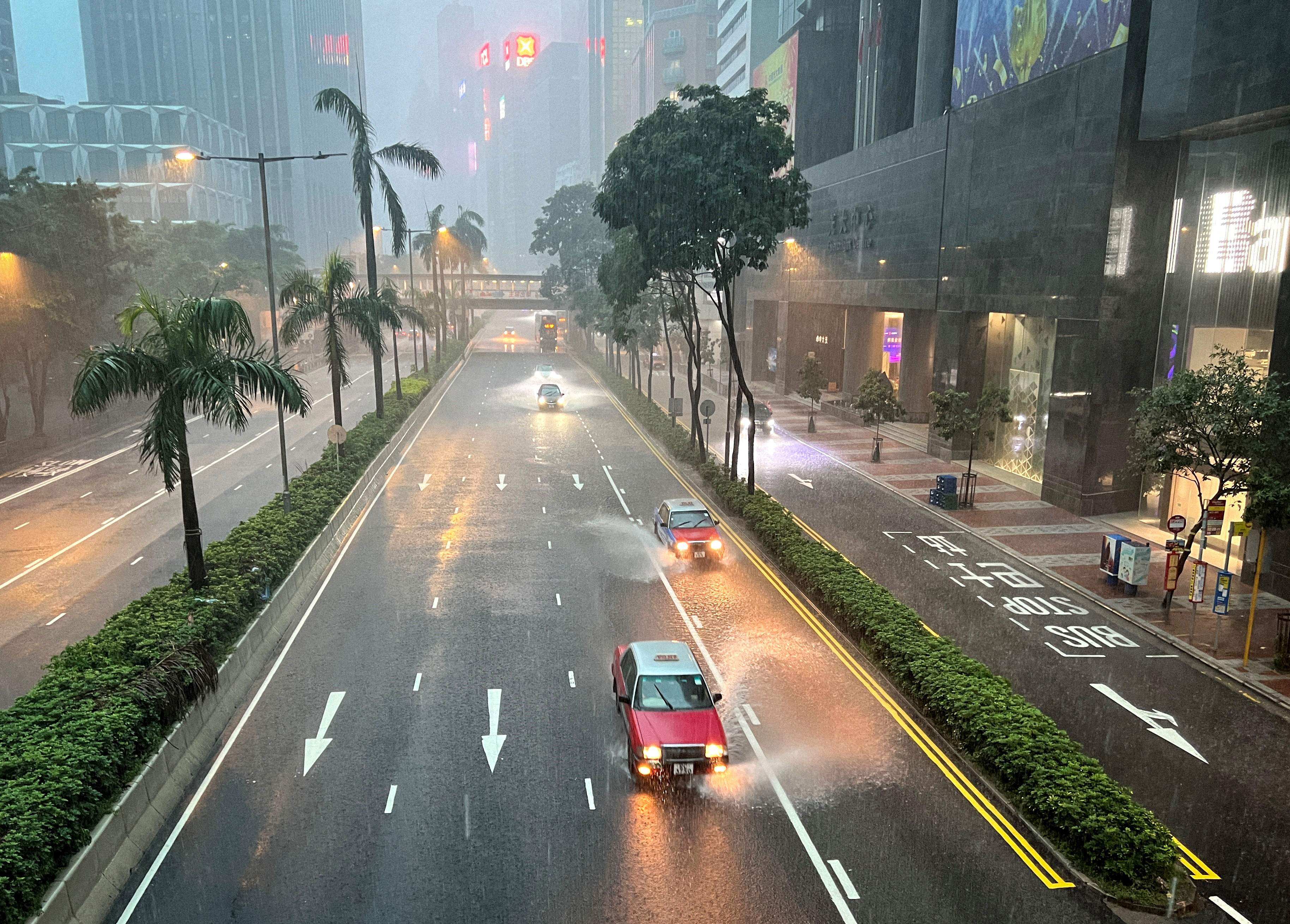 Taxis and other vehicles drive along a waterlogged Gloucester Road in Wan Chai district on August 5. Hong Kong currently requires drivers “to read at a distance of 23m in good daylight a vehicle number plate”. Photo: AFP
