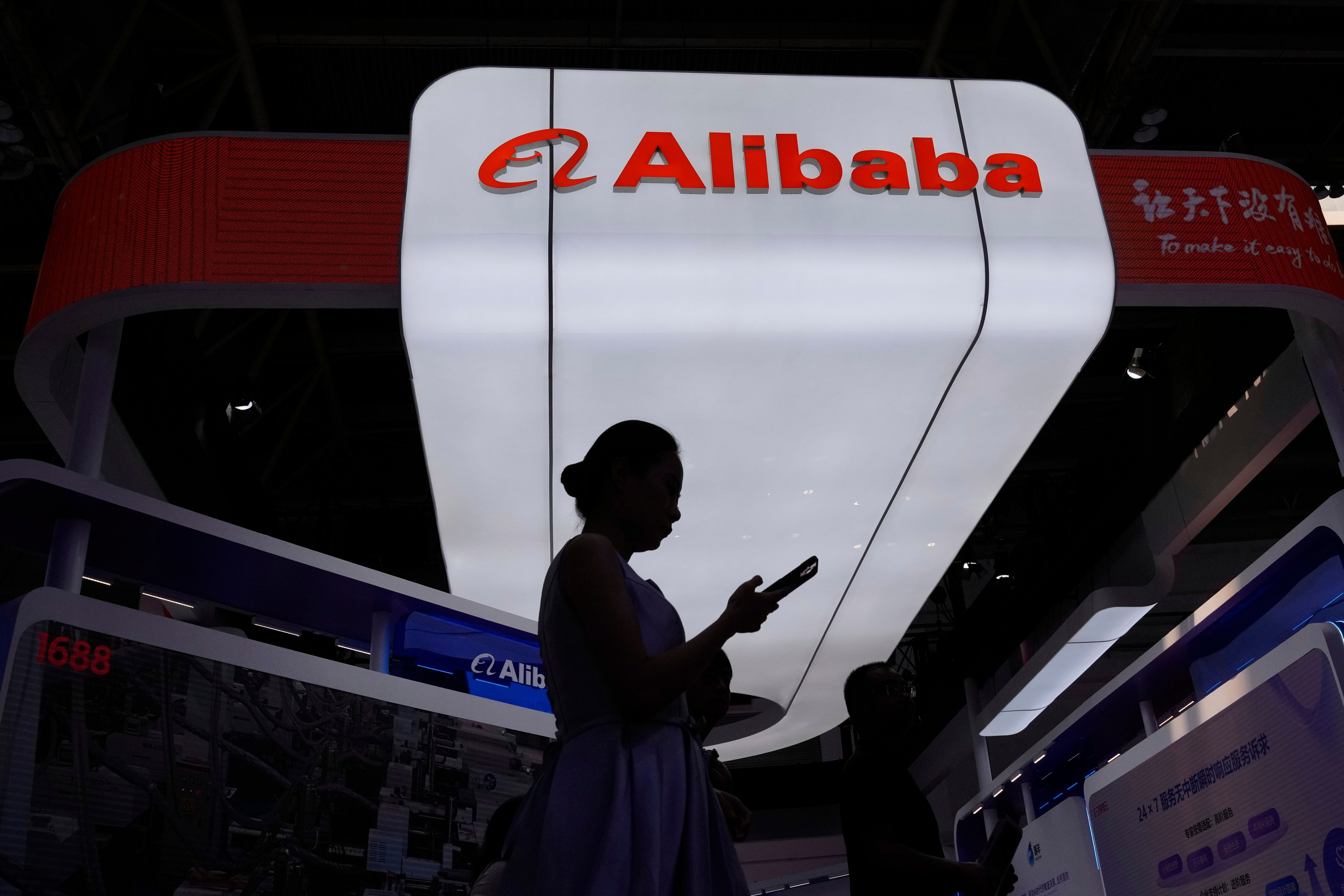 A visitor walks in front of Alibaba’s booth during the 3rd China International Supply Chain Expo in Beijing, July 18, 2025. Photo: AP