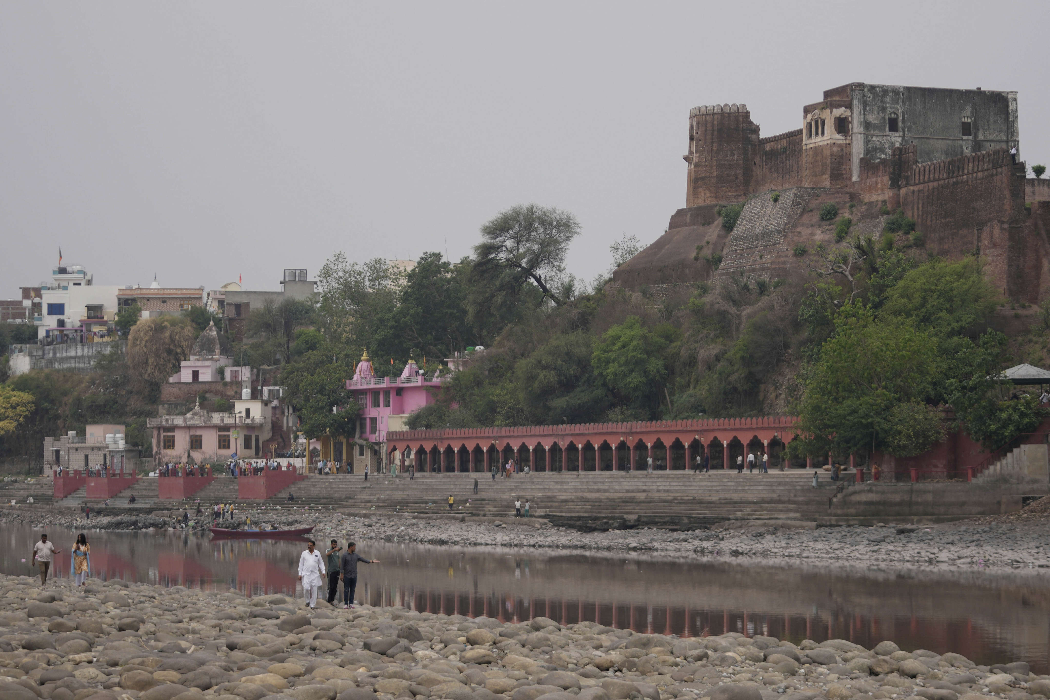 People walk along dry parts of the Chenab River after the water was halted by a dam at Akhnoor, on the outskirts of Jammu, India, on May 5. Photo: AP
