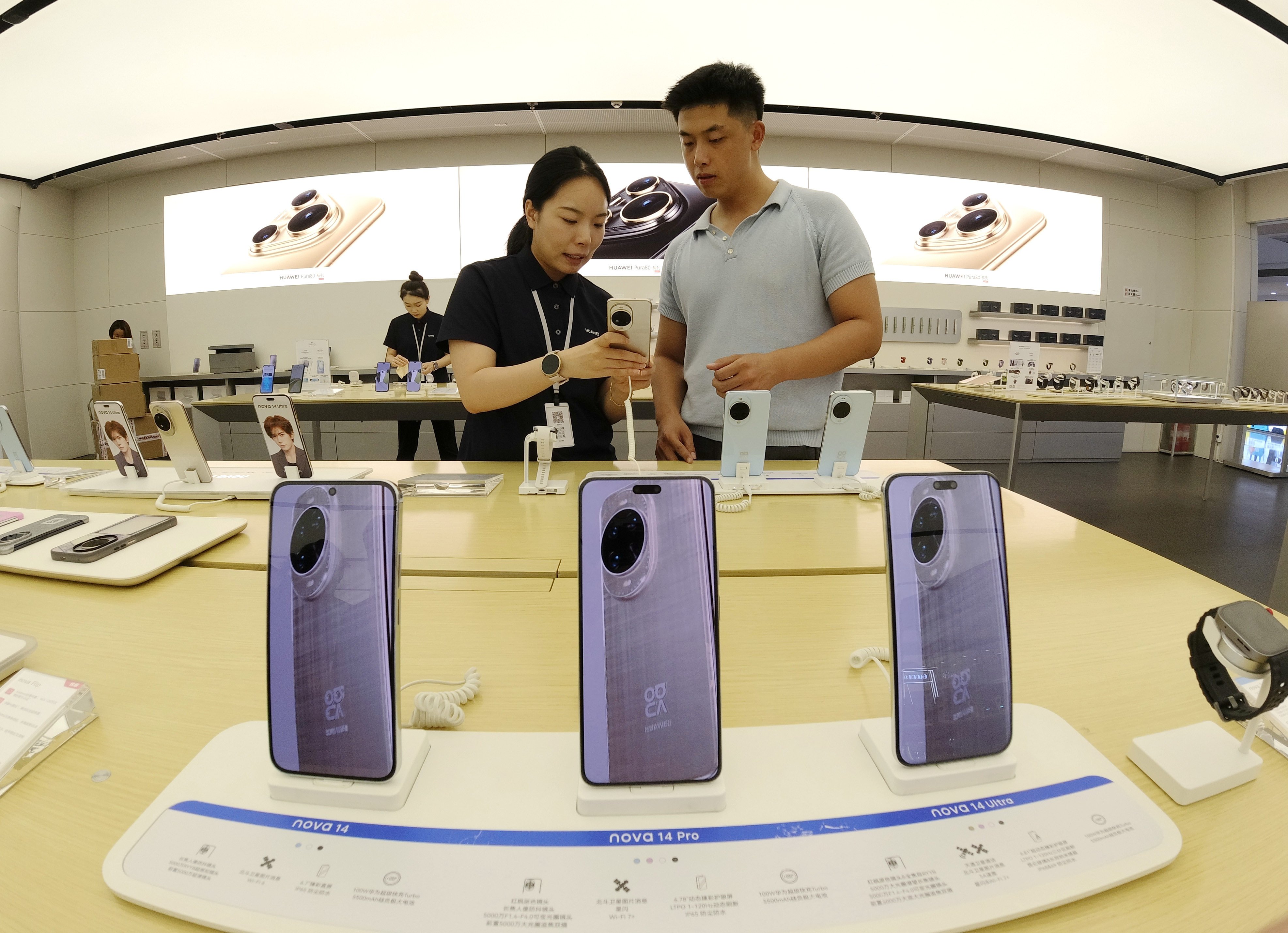 A customer checks out a mobile phone at a store in Binzhou City, in China’s Shandong province, on August 9. Photo: Xinhua