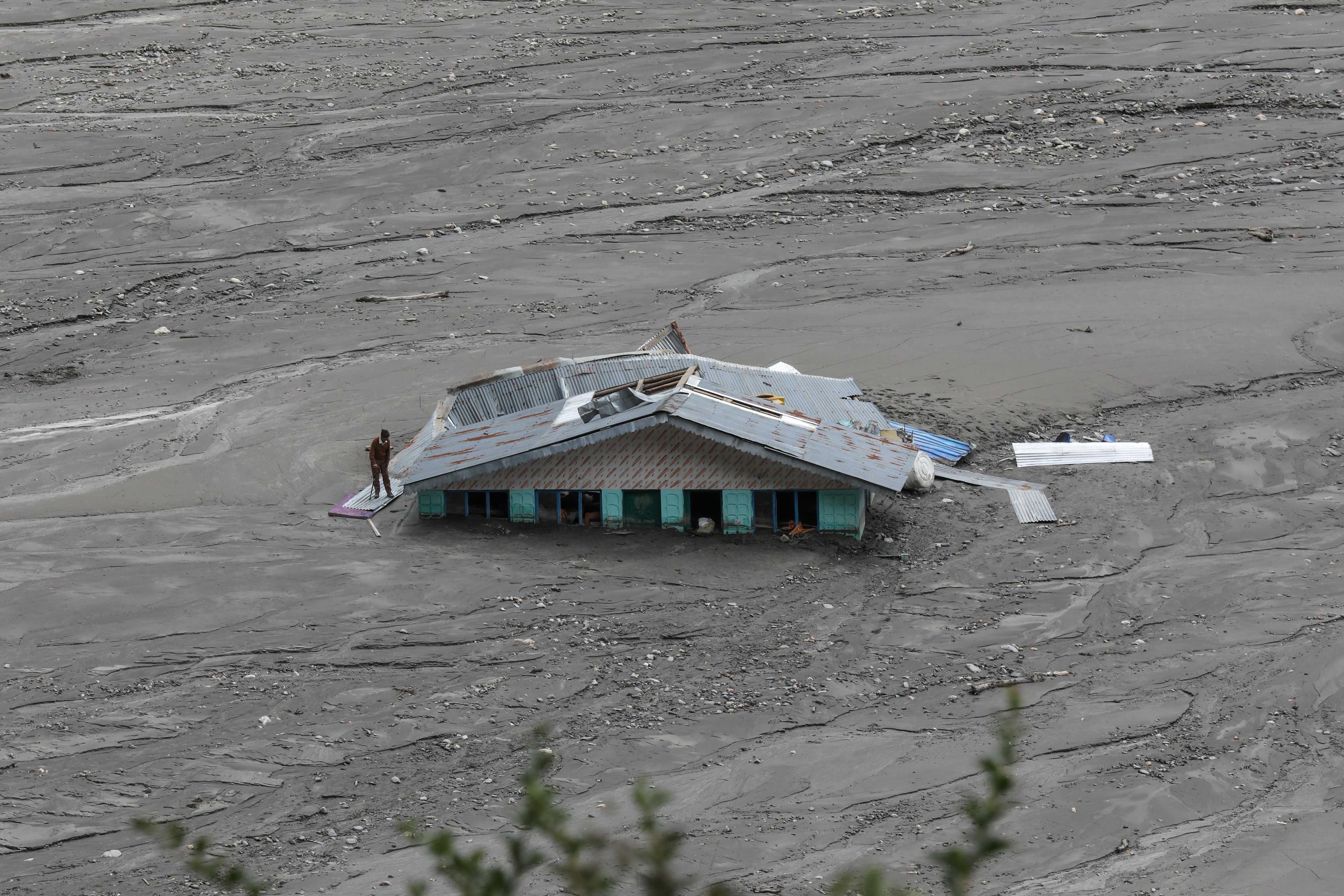 A man looks at a mud-covered house after a cloudburst in Uttarakhand, India, on Monday. Photo: EPA