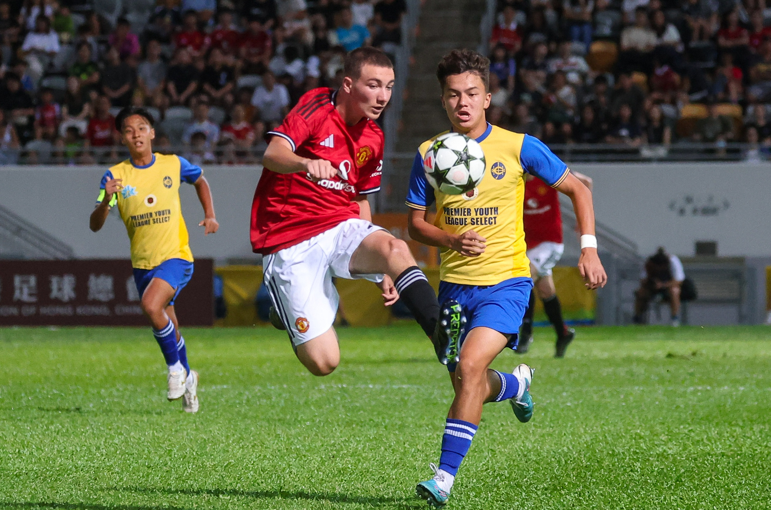Manchester United ‘s Samuel (left) is pursued by Hong Kong’s Calum Howard in their match at Mong Kok on Friday. Photo: Edmond So