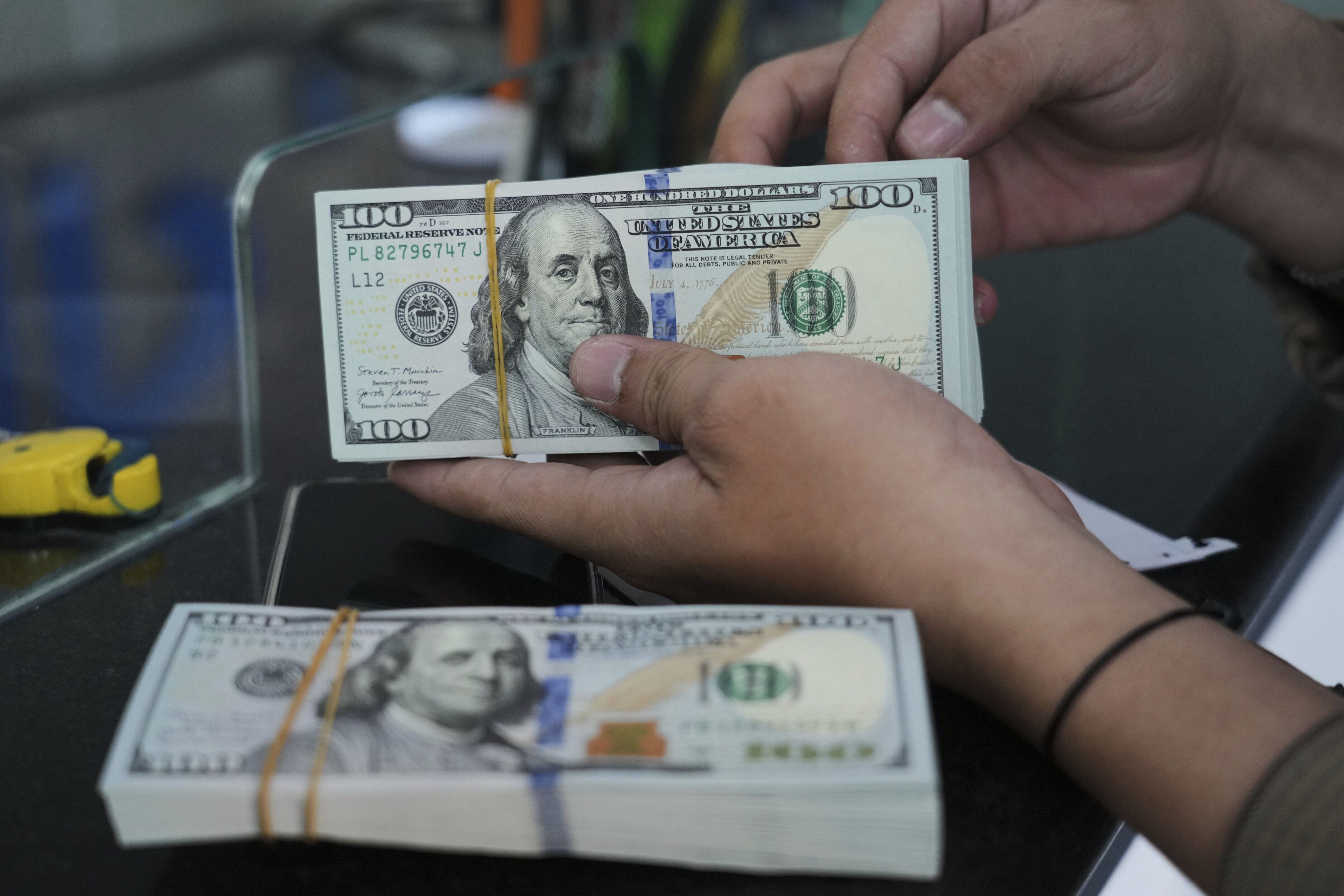 An employee counts US dollar bank notes at a money changer in Jakarta. SMEs often operate on thin margins and require steady cash flows to survive. Photo: AP