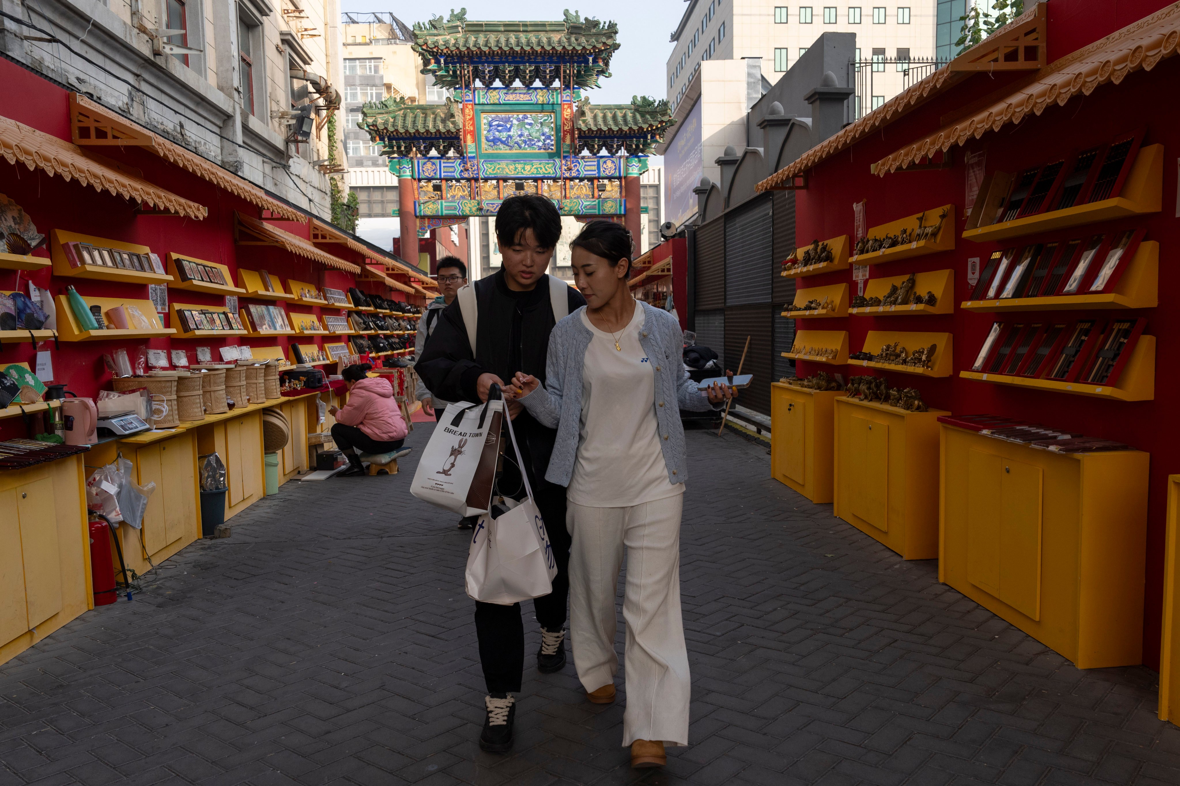Shoppers walk past a row of outdoor stalls in central Beijing. China has made driving up domestic consumption a key policy priority this year. Photo: AP