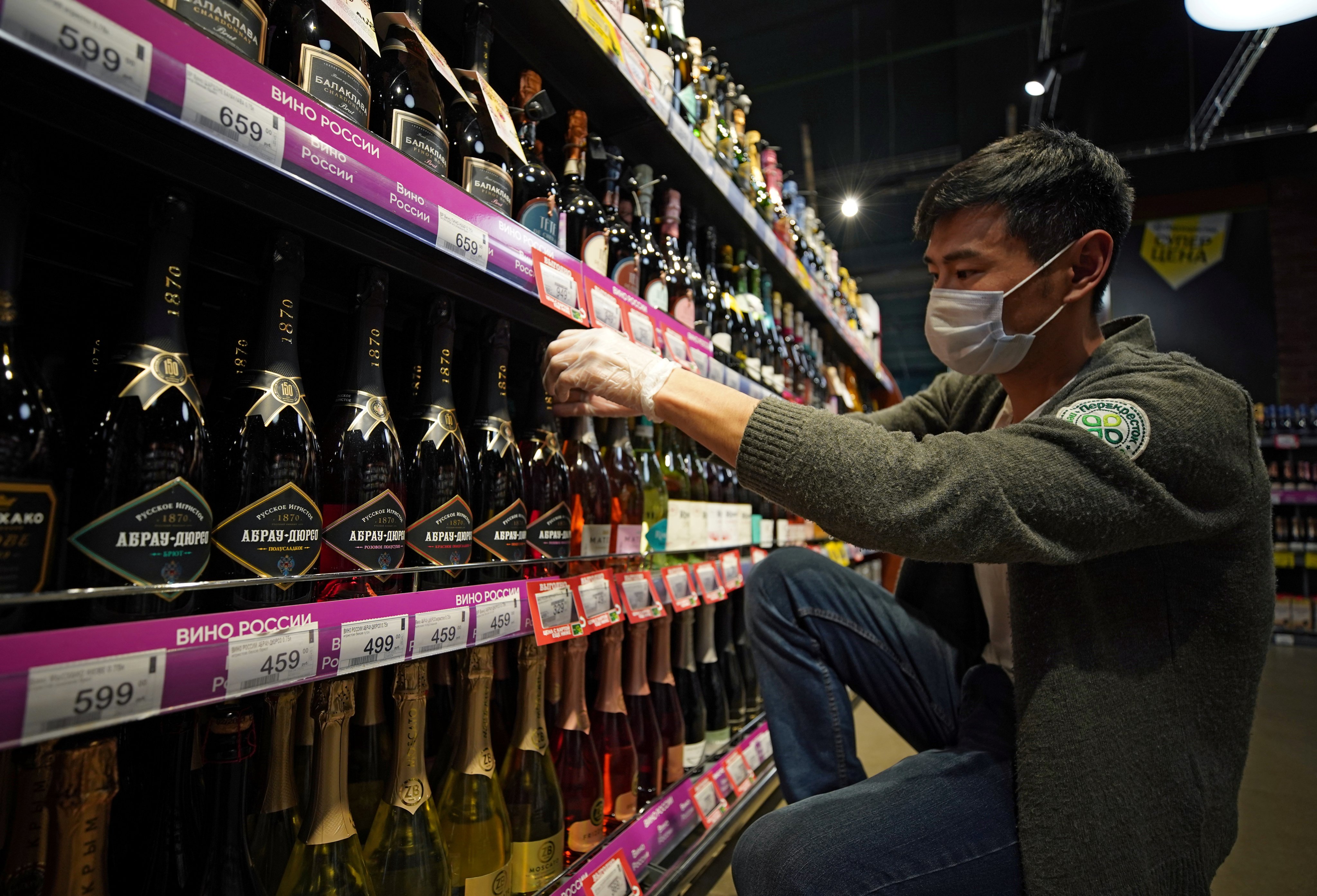 A worker arranges bottles of Russian sparkling wine at a supermarket in Moscow. Photo: Reuters