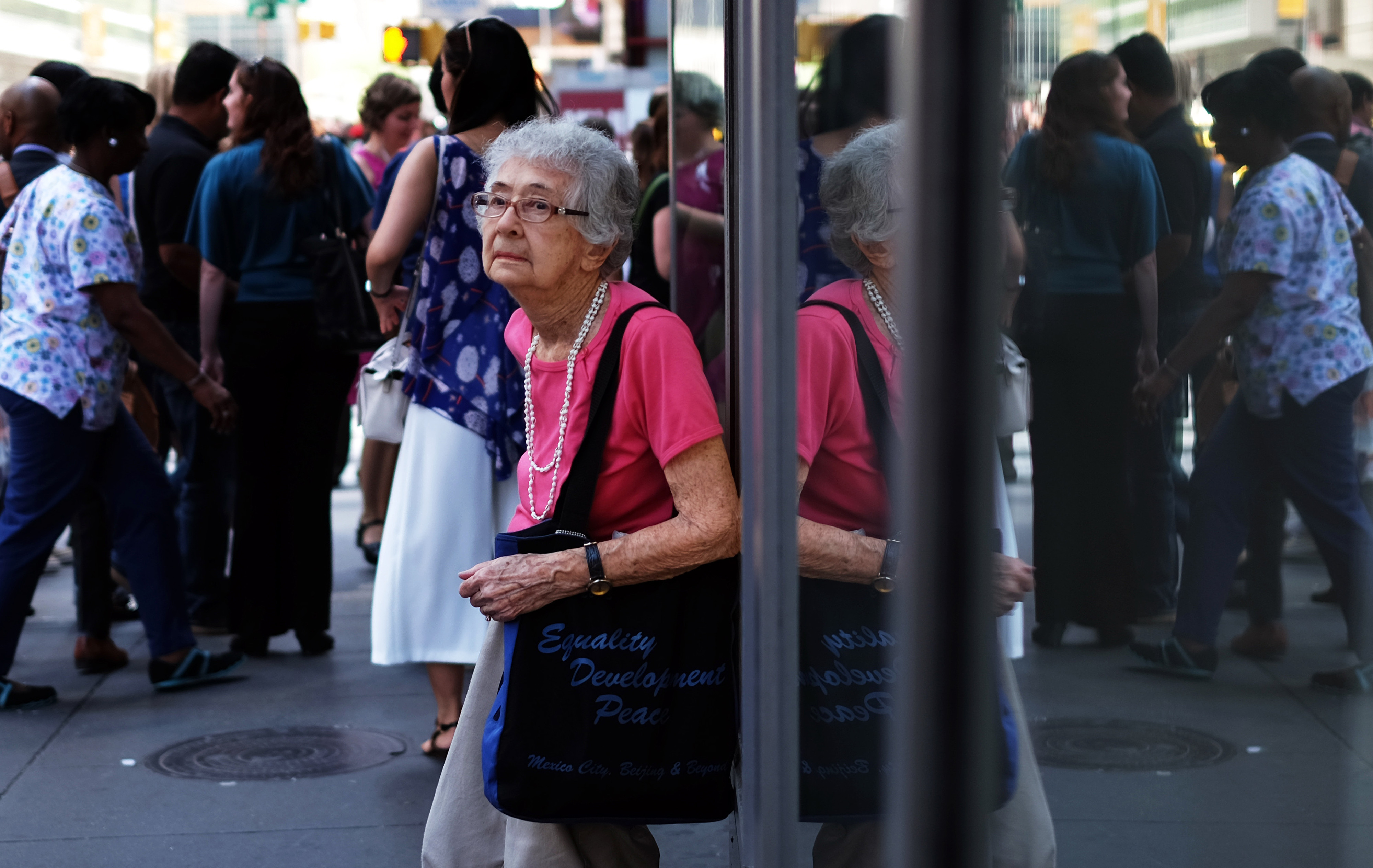 An elderly woman rests leans against a shop window in New York on June 25, 2015. Photo: AFP
