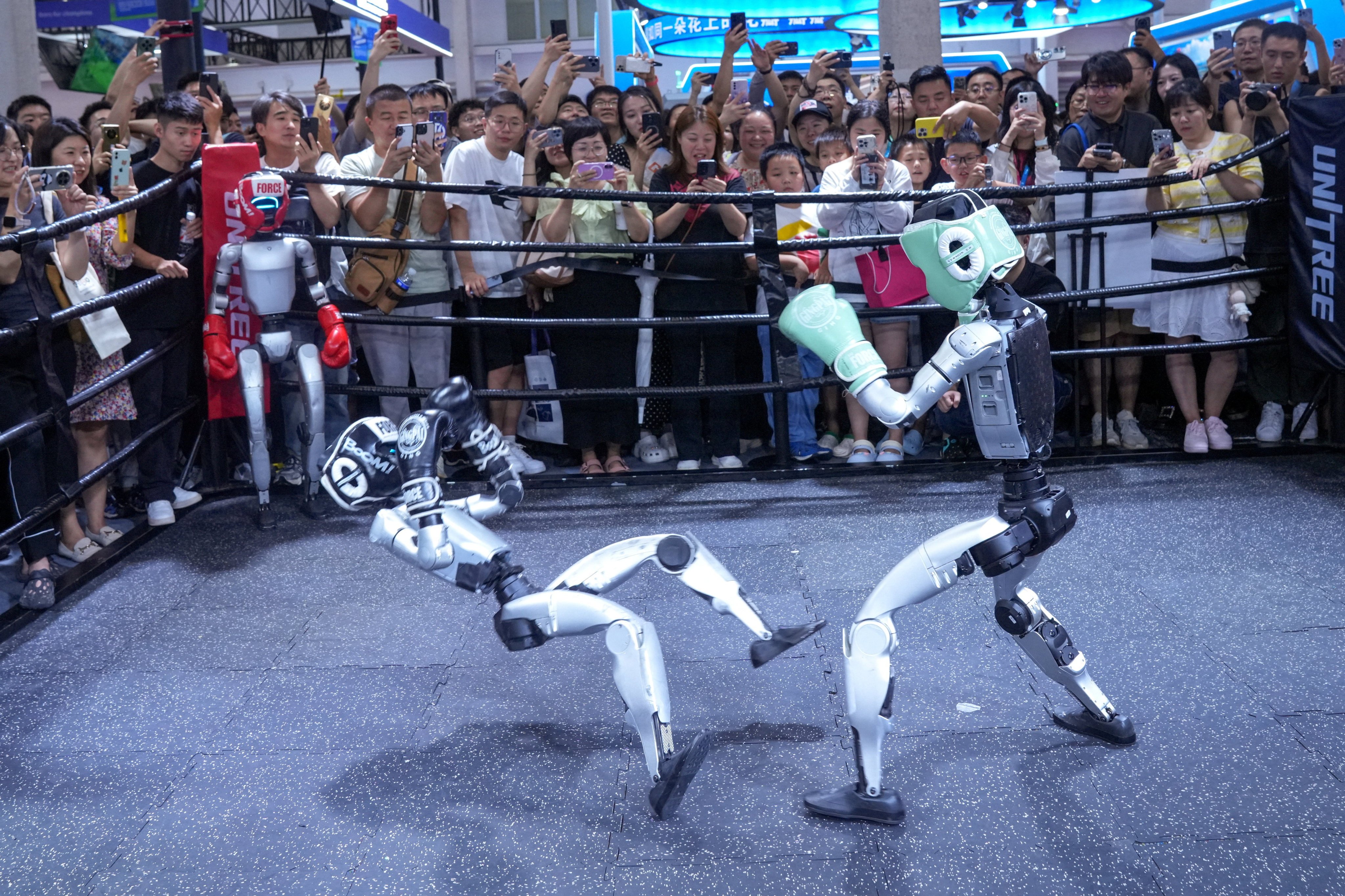 Visitors watch humanoid robots fight at the Unitree Robotics booth during the World Robot Conference in Beijing. China has invested heavily in artificial intelligence, robotics and other emerging sectors in recent years. Photo: Reuters
