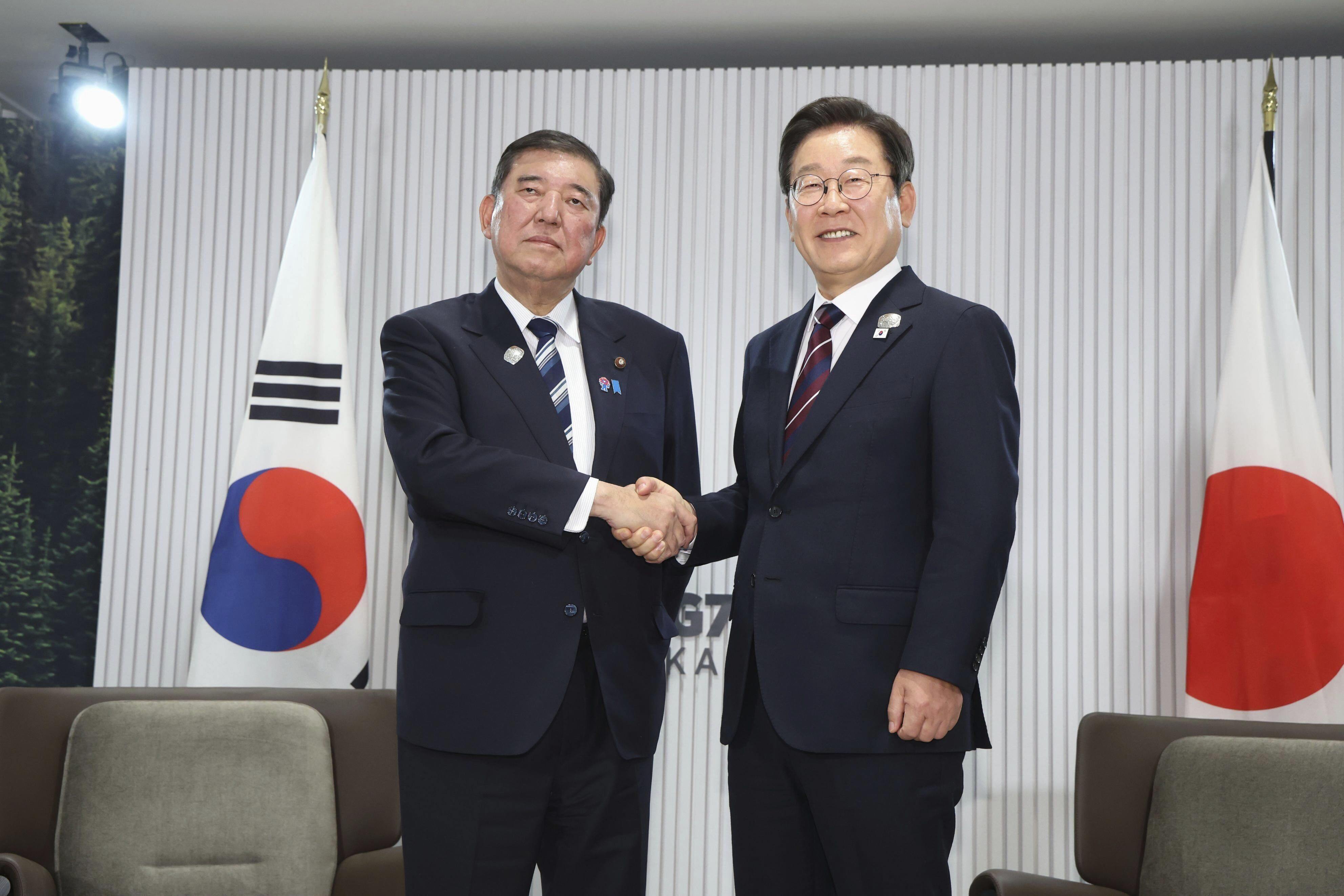 Japanese Prime Minister Shigeru Ishiba (left) and South Korean President Lee Jae-myung shake hands ahead of a bilateral meeting on the sidelines of the G7 summit on June 17. Photo: Kyodo/AP