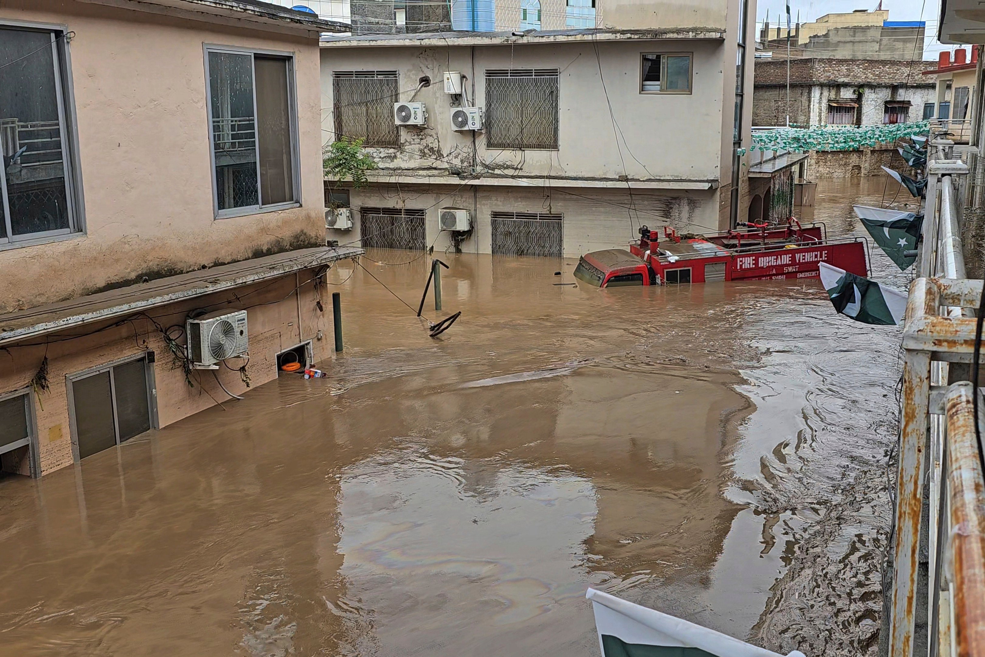 A fire engine is sugmerged in floodwaters following heavy rains in Mingora, the main town of Swat Valley in Pakistan on Friday. Photo: AP