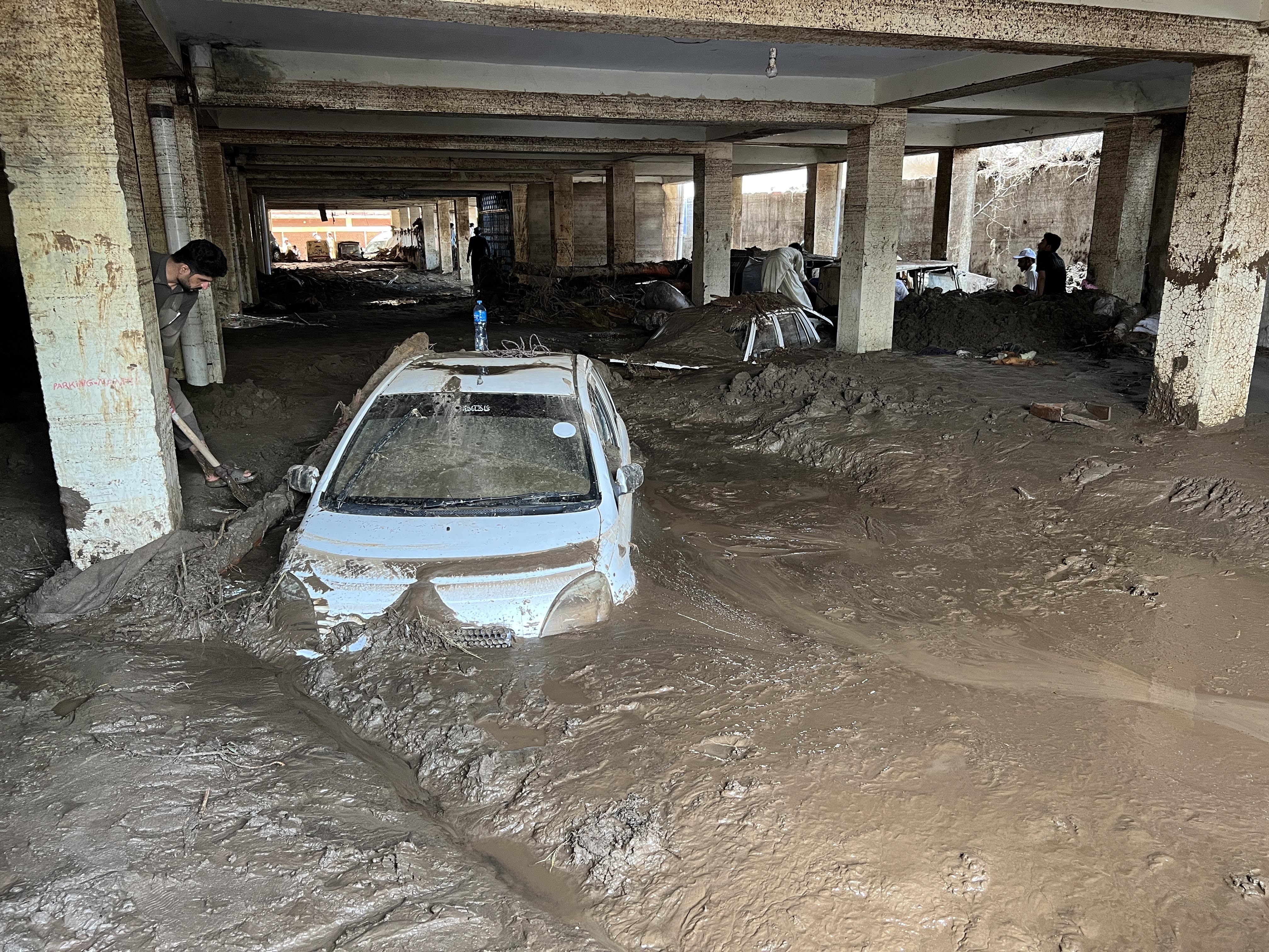 People struggle to retrieve cars from mud after devastating floods in Pakistan’s Khyber Pakhtunkhwa province. Photo: Xinhua