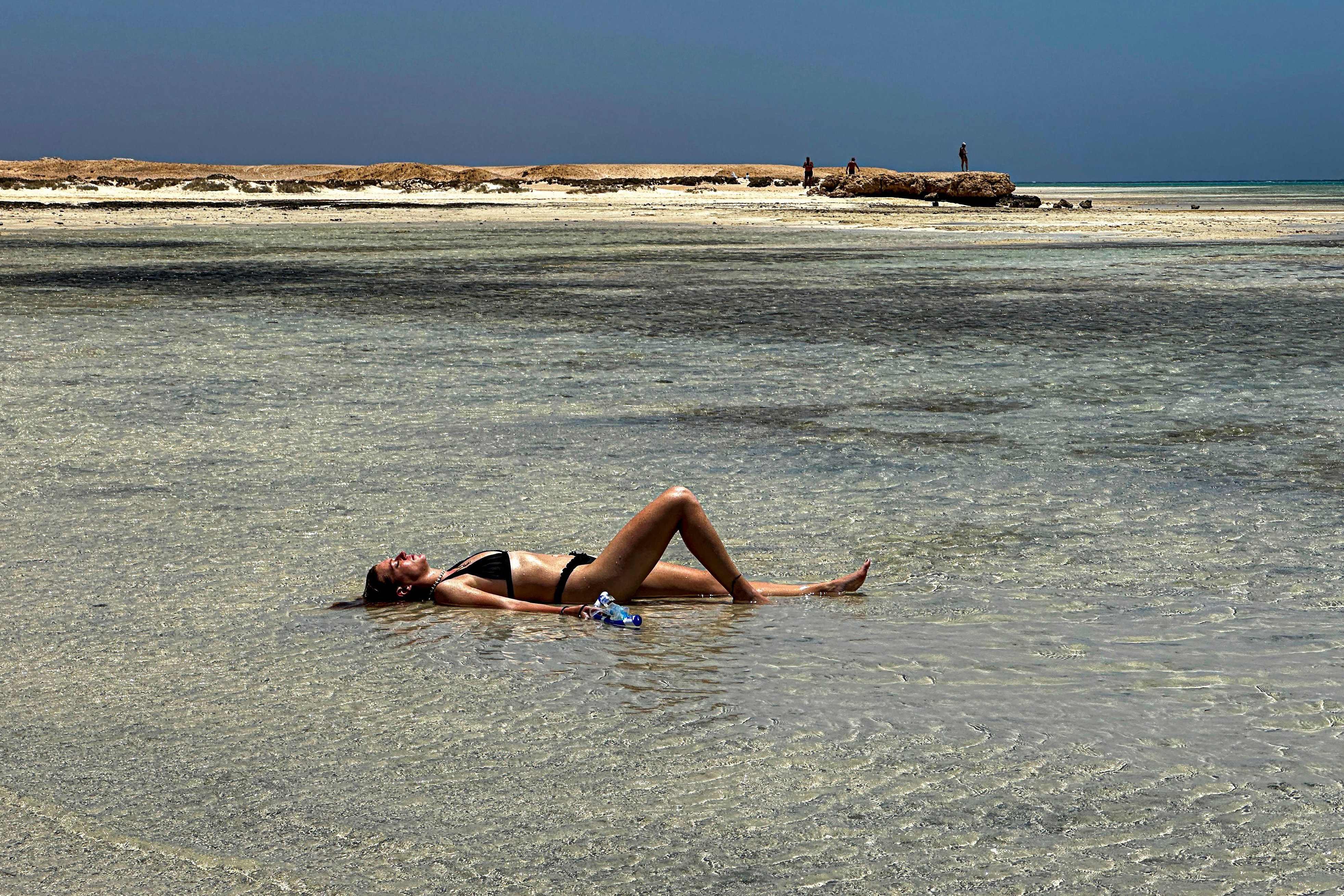 A tourist lies in the shallow waters of the Ras Hankorab beach in Egypt’s Red Sea Wadi Al-Gemal protectorate  on May 28. Photo: AFP