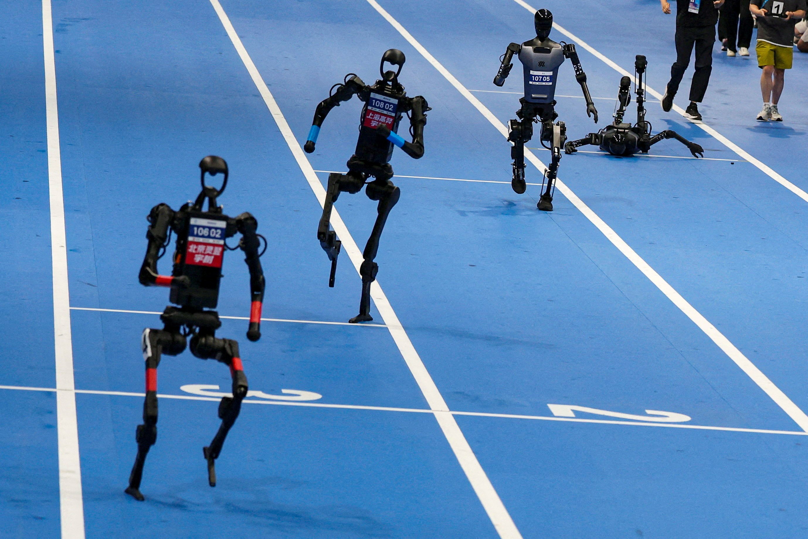 Robots compete in the 100-metre final on Sunday at the inaugural World Humanoid Robot Games in Beijing. Photo: Reuters
