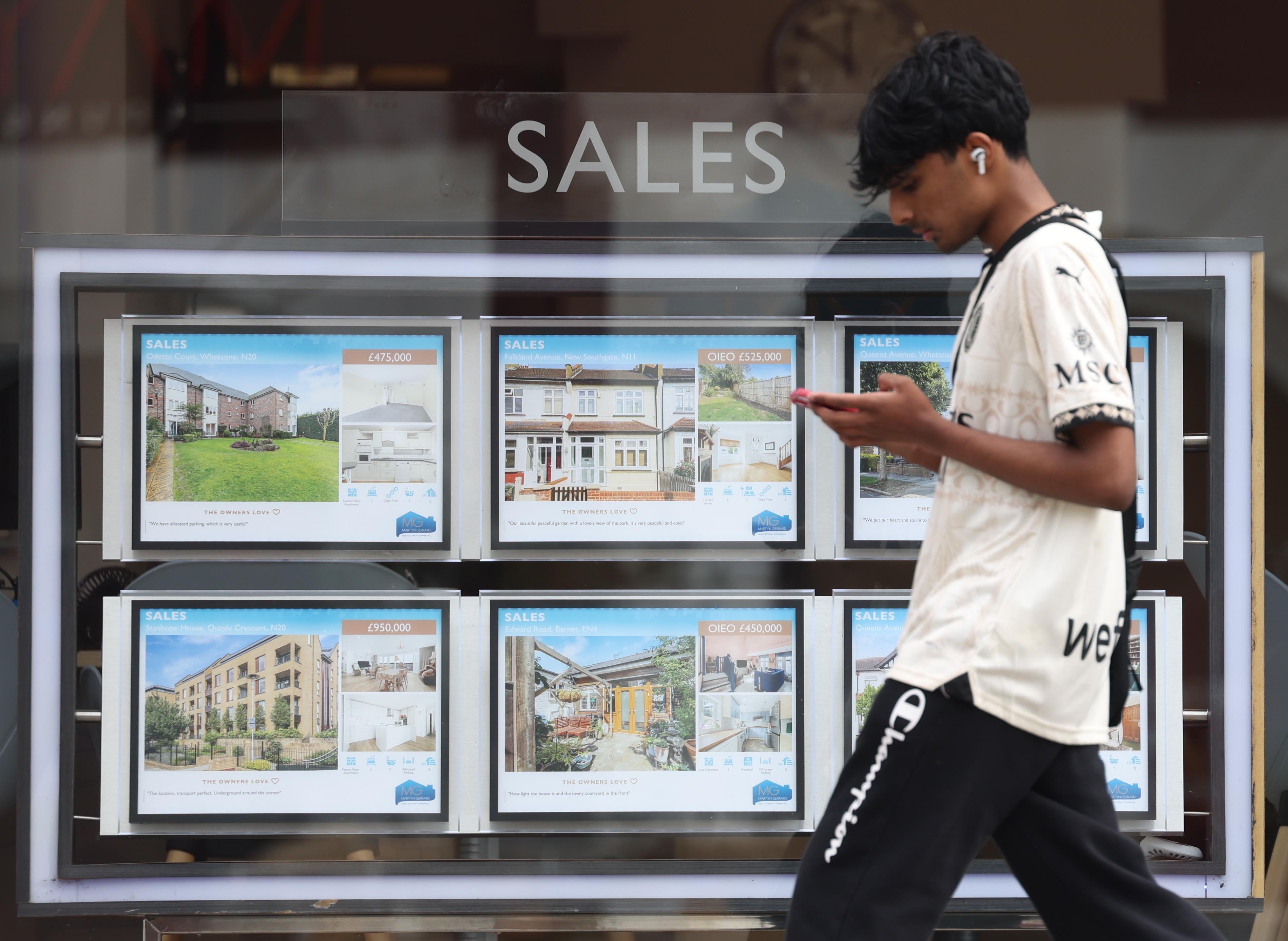A person walks past an estate agent’s properties listing in London, on August 7. The average home prices fell by 1.3 per cent this month. Photo: EPA