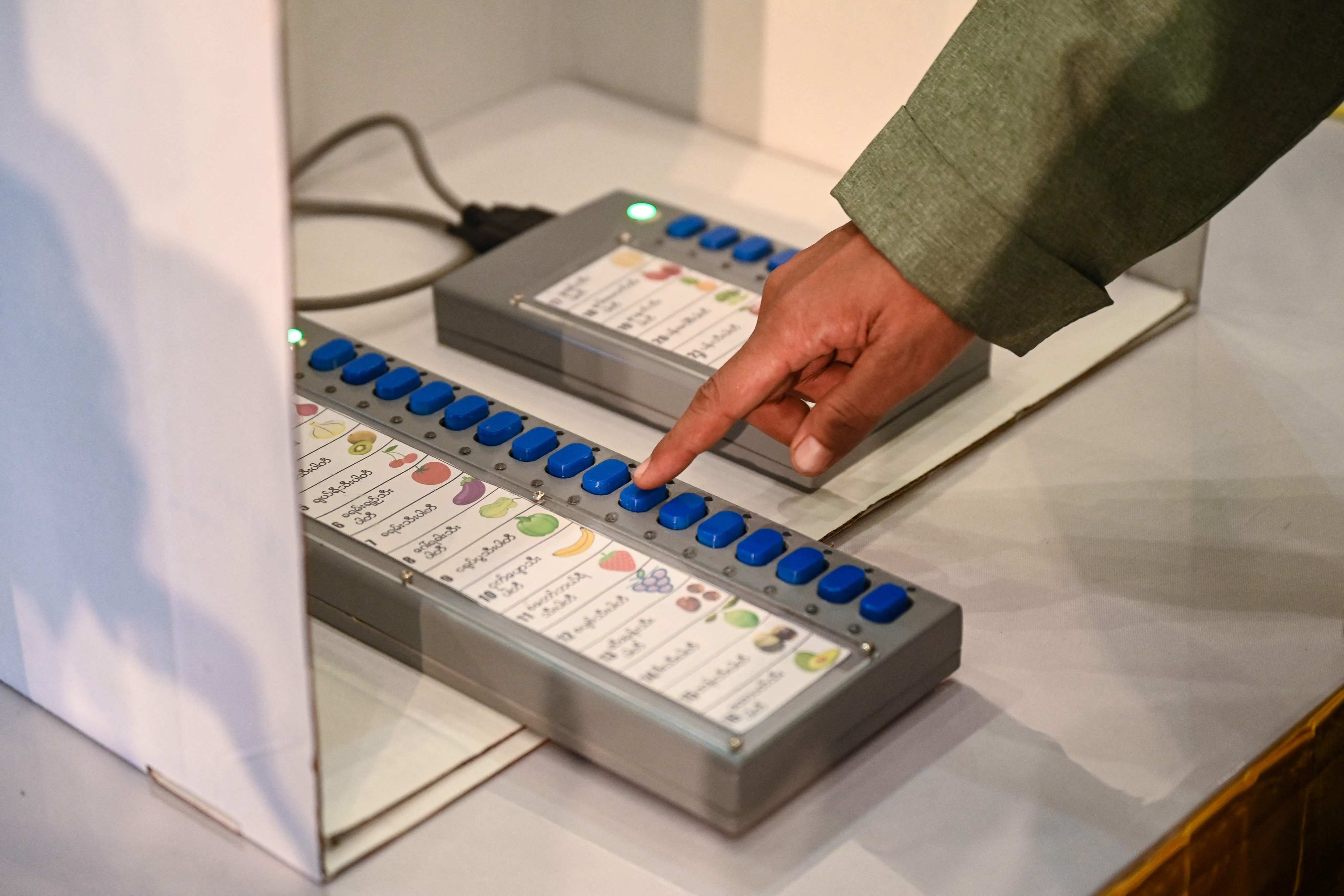 A Myanmese official shows how to use a voting machine for elections in Yangon. Photo: AFP