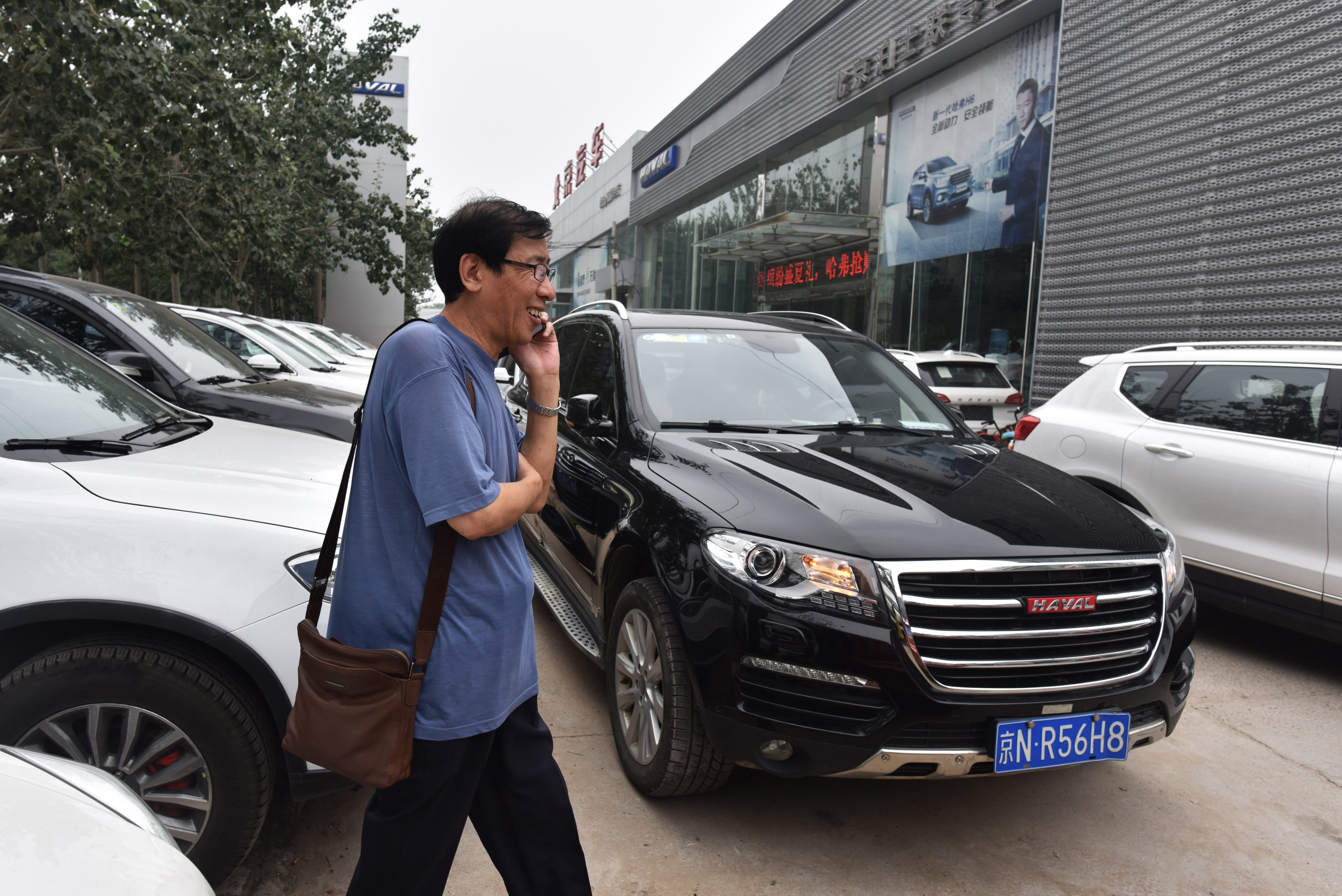 A man walks past Haval brand SUVs made by Great Wall Motor, outside a showroom in Beijing on August 22, 2017. Photo: AFP