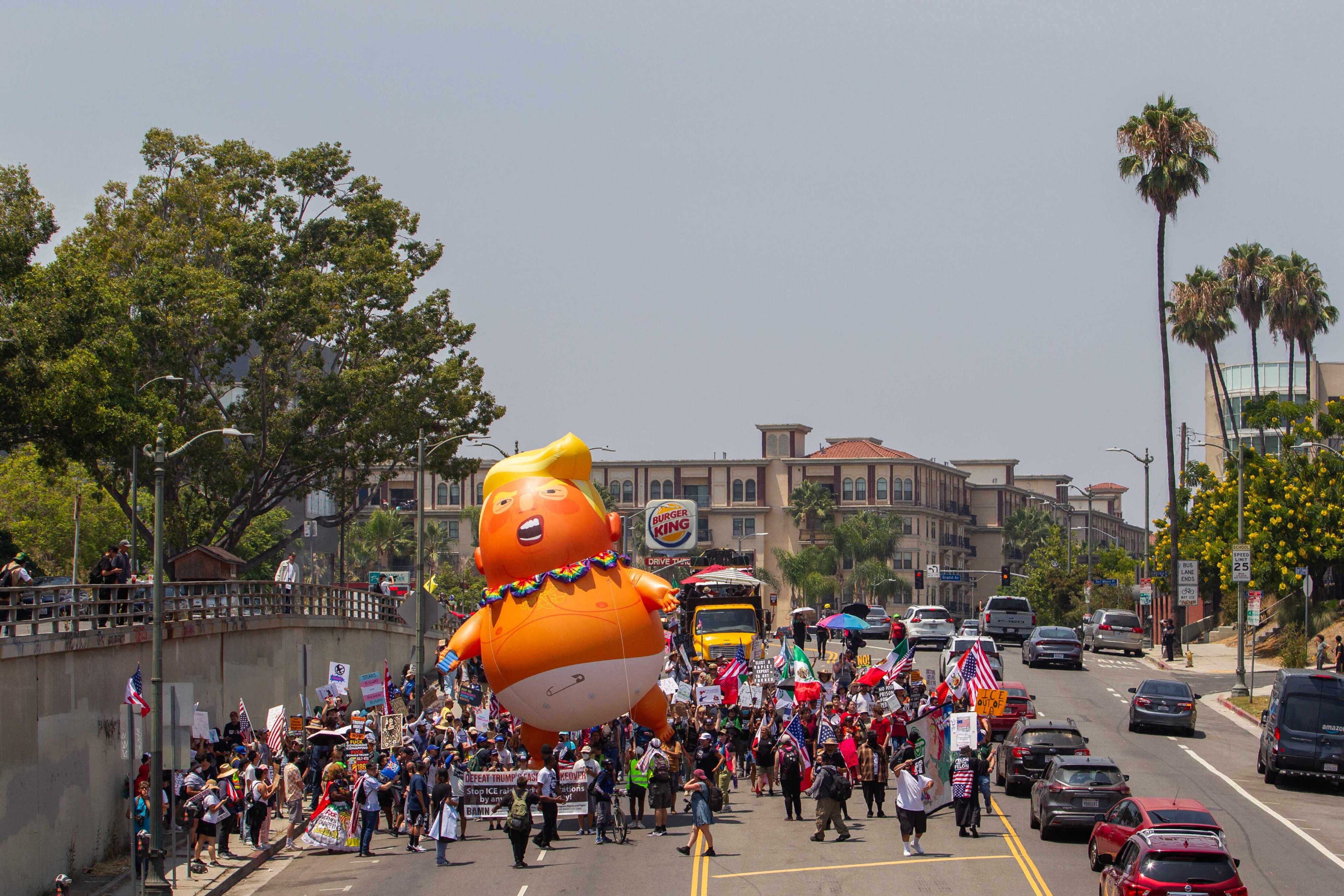 Anti-Trump protesters holding a Trump balloon march in Los Angeles, California, on August 2. Photo: Getty Images via AFP