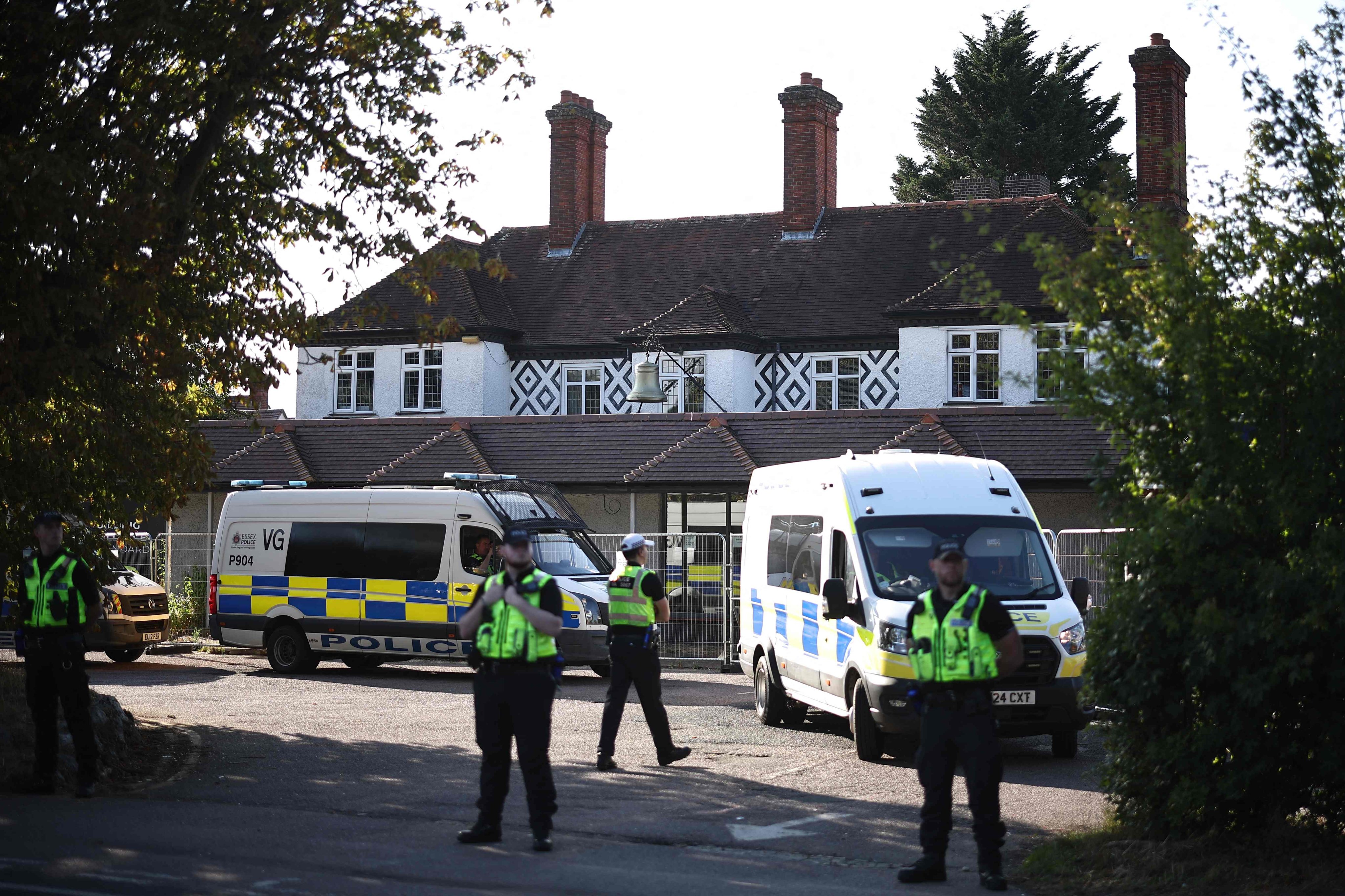 Police officers stand outside the The Bell Hotel, which houses asylum seekers, in Epping, northeast of London. Photo: AFP