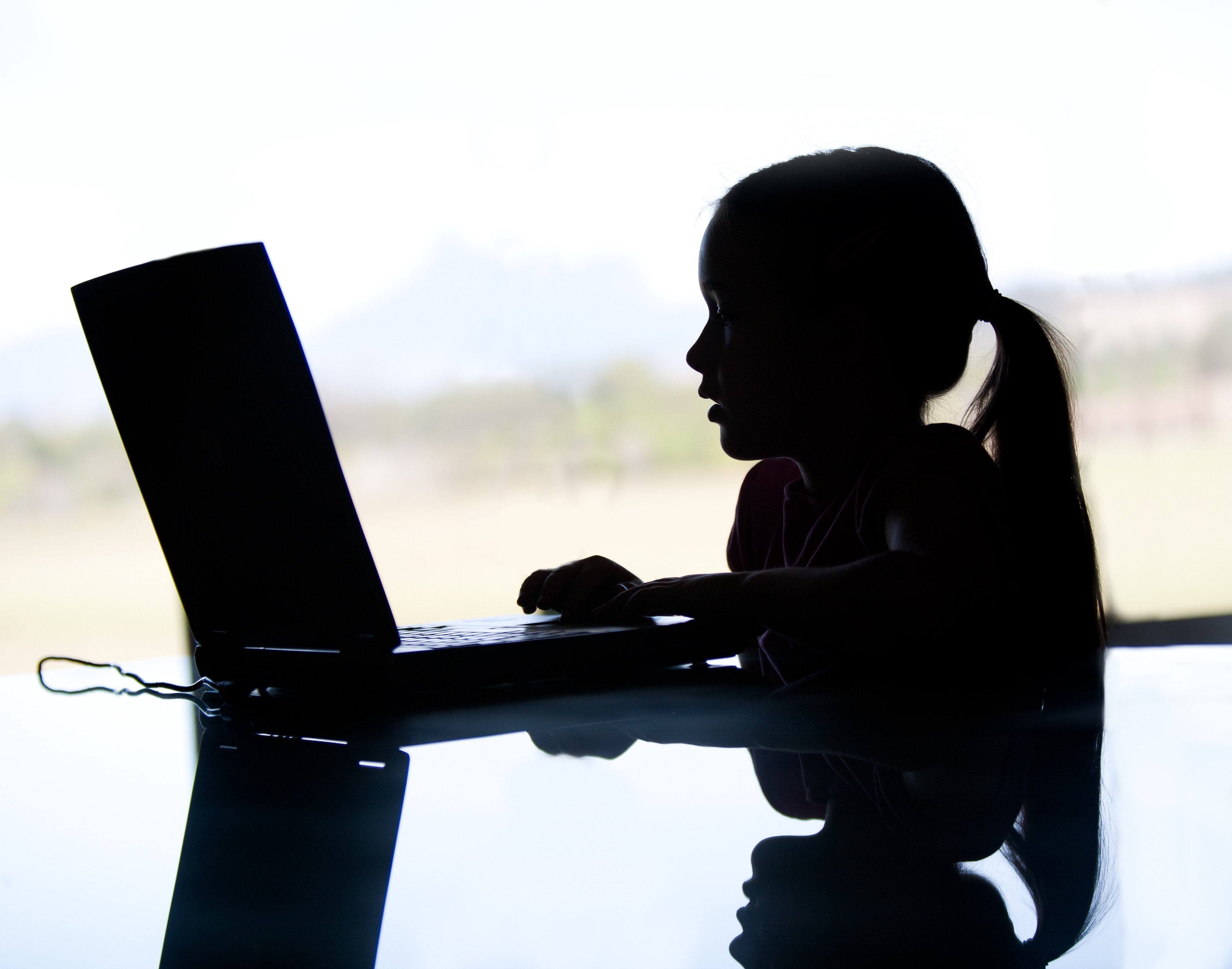 Silhouette of a young girl on the computer. A 12-year-old girl in Malaysia was found to be running a WhatsApp group peddling pornographic photos. Photo: Shutterstock