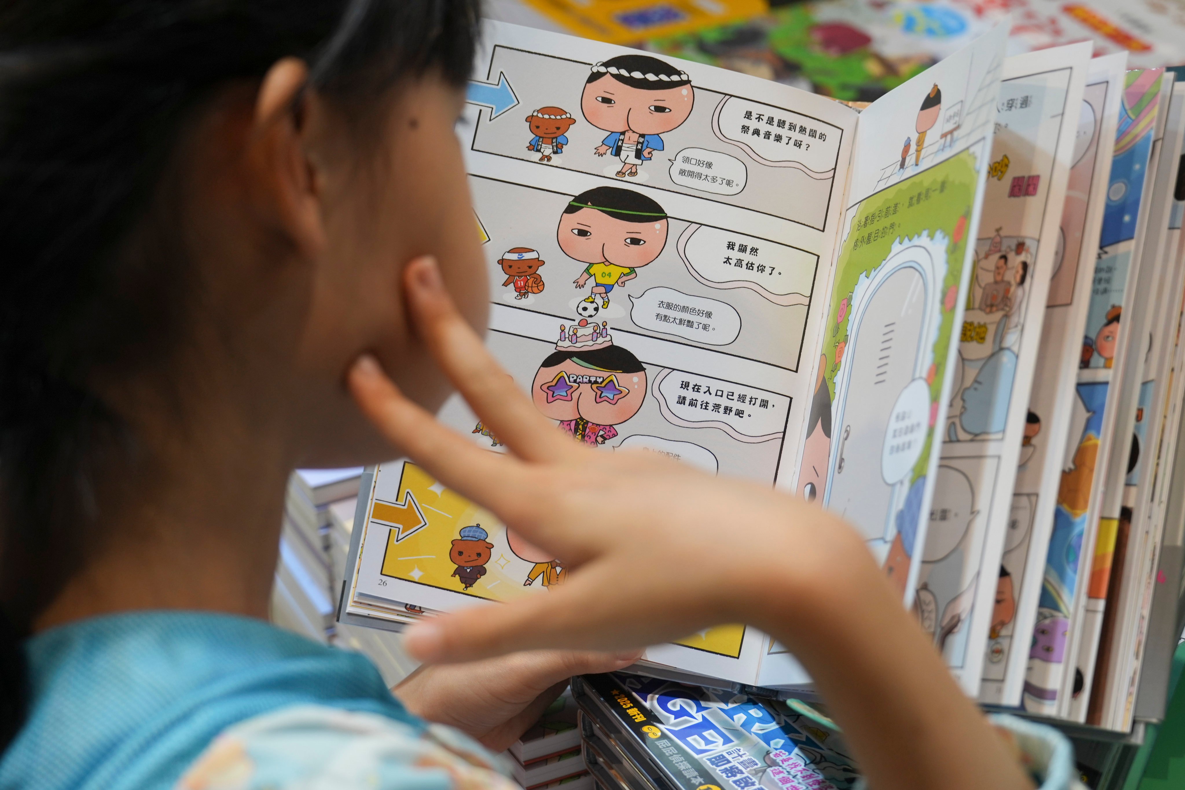 A child reads a comic book at the Hong Kong Book Fair in July. Malaysian authorities are hoping comics can attract children to their anti-corruption message. Photo: Sam Tsang