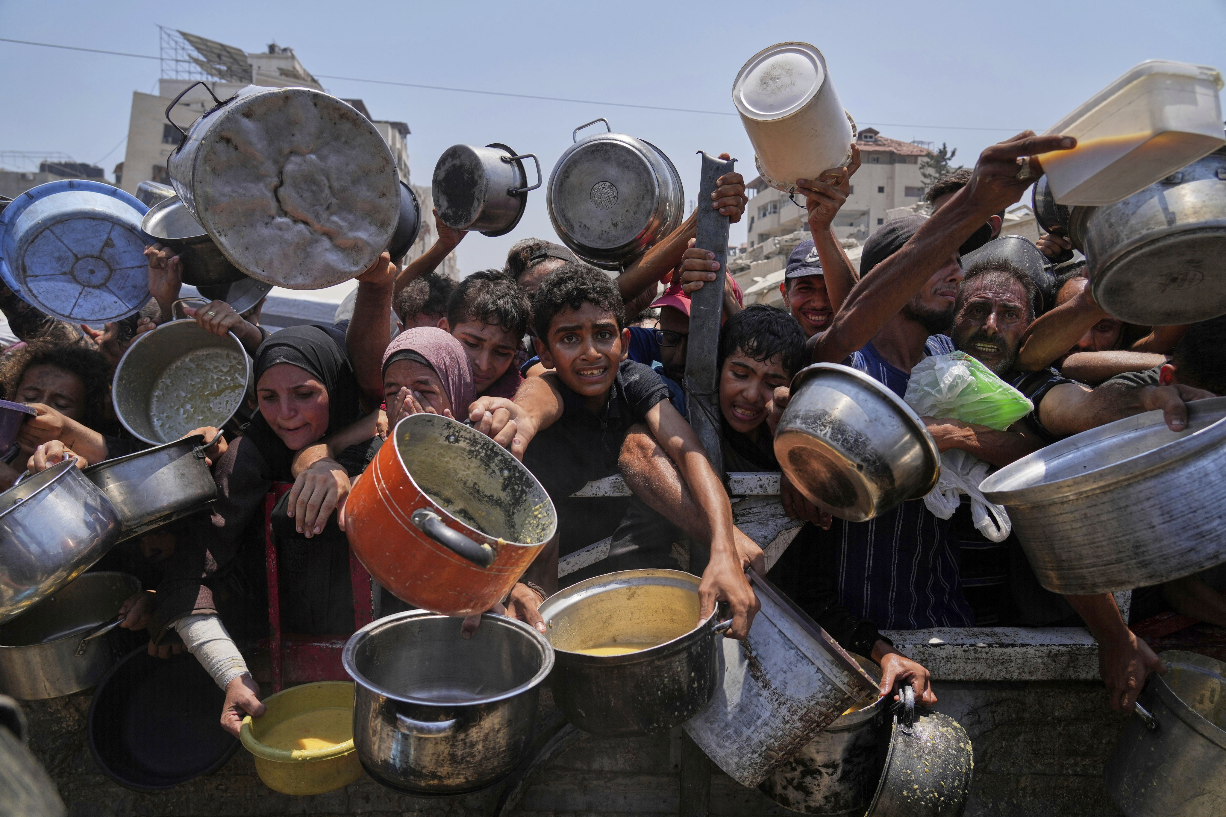 Palestinians struggle to get donated food at a community kitchen in Gaza City, northern Gaza Strip, July 26. Photo: AP