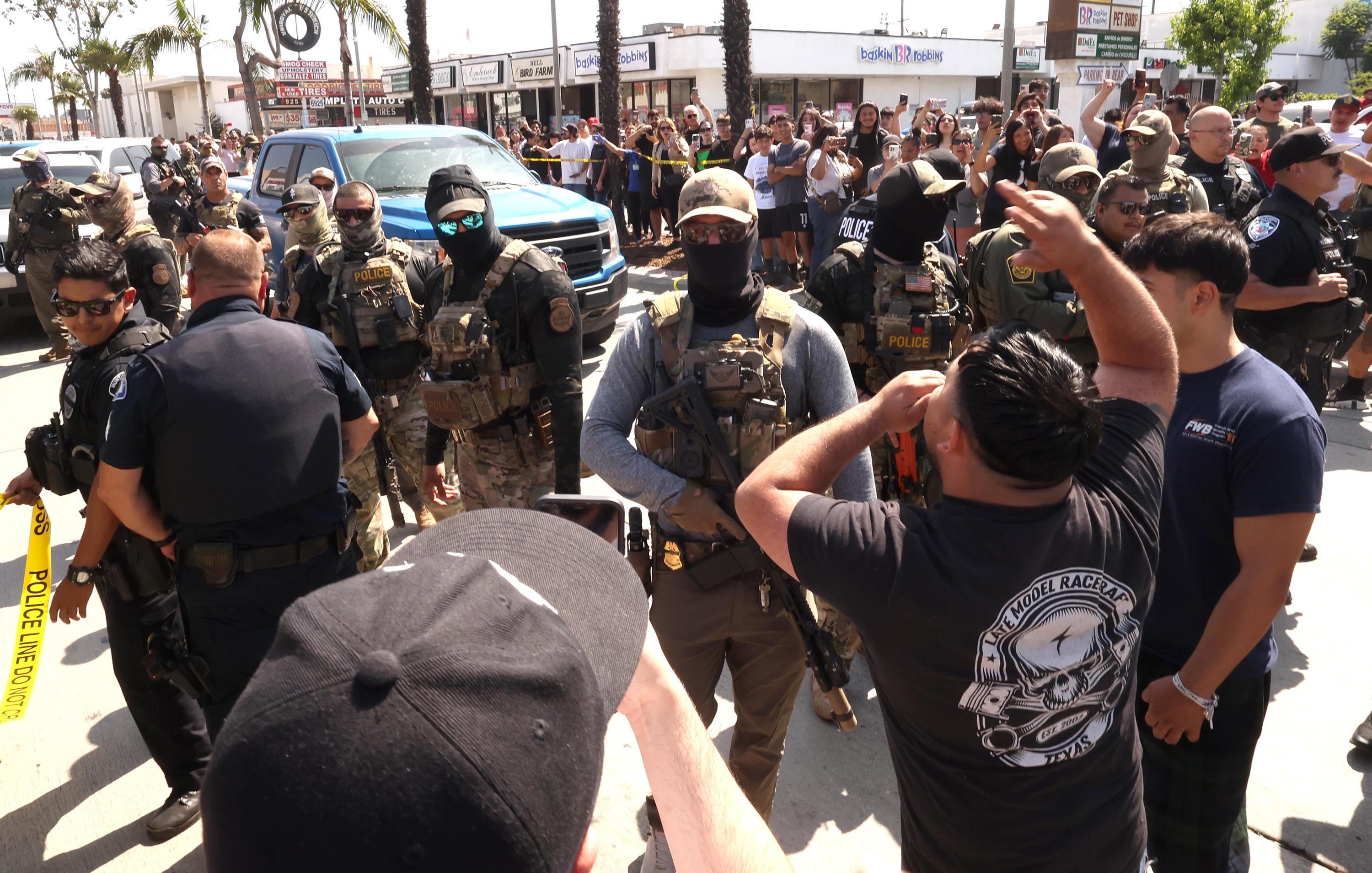 Residents confront ICE and Border Patrol agents over a raid in the city of Bell, California in June. Photo: TNS