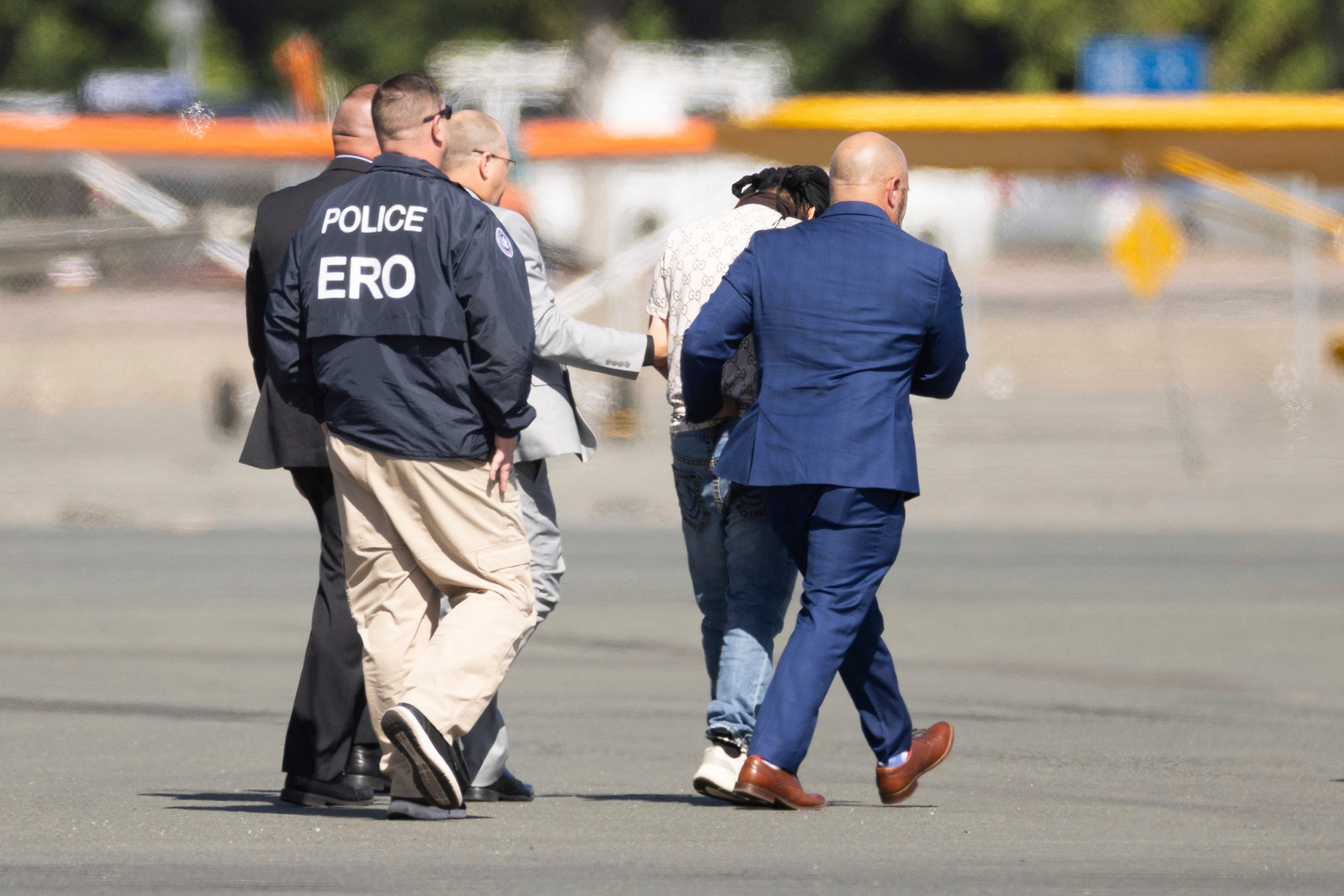 Harjinder Singh is escorted to a plane by Florida Lieutenant Governor Jay Collins (right) and law enforcement officials in Stockton, California, on August 21. Photo: AP