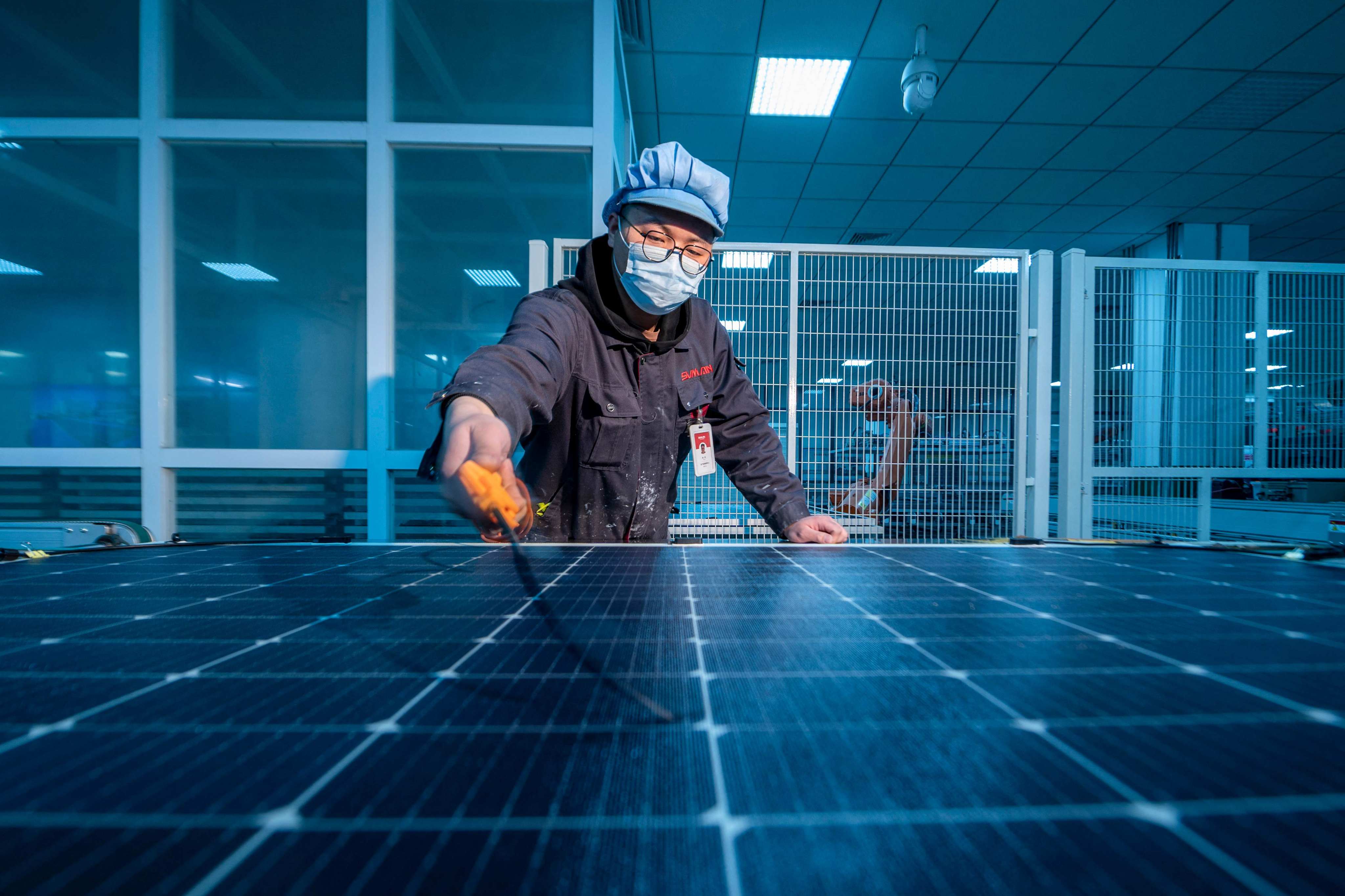 A worker produces solar photovoltaic modules for export at a factory in Yangzhong, Jiangsu province, in February 2023. Photo: AFP