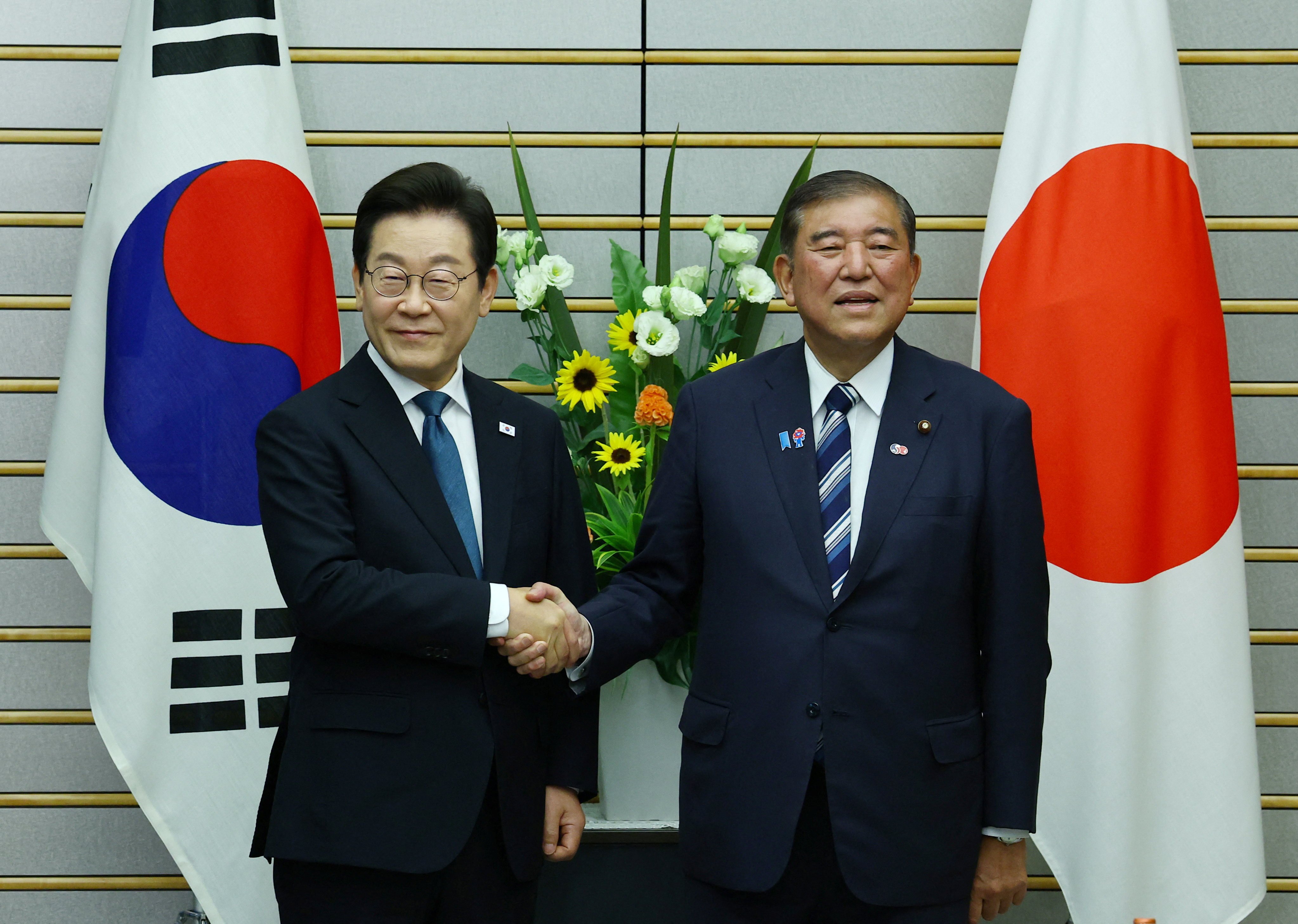 South Korea’s President Lee Jae-myung (left) shakes hands with Japan’s Prime Minister Shigeru Ishiba in Tokyo, Japan on Saturday. Photo: Reuters