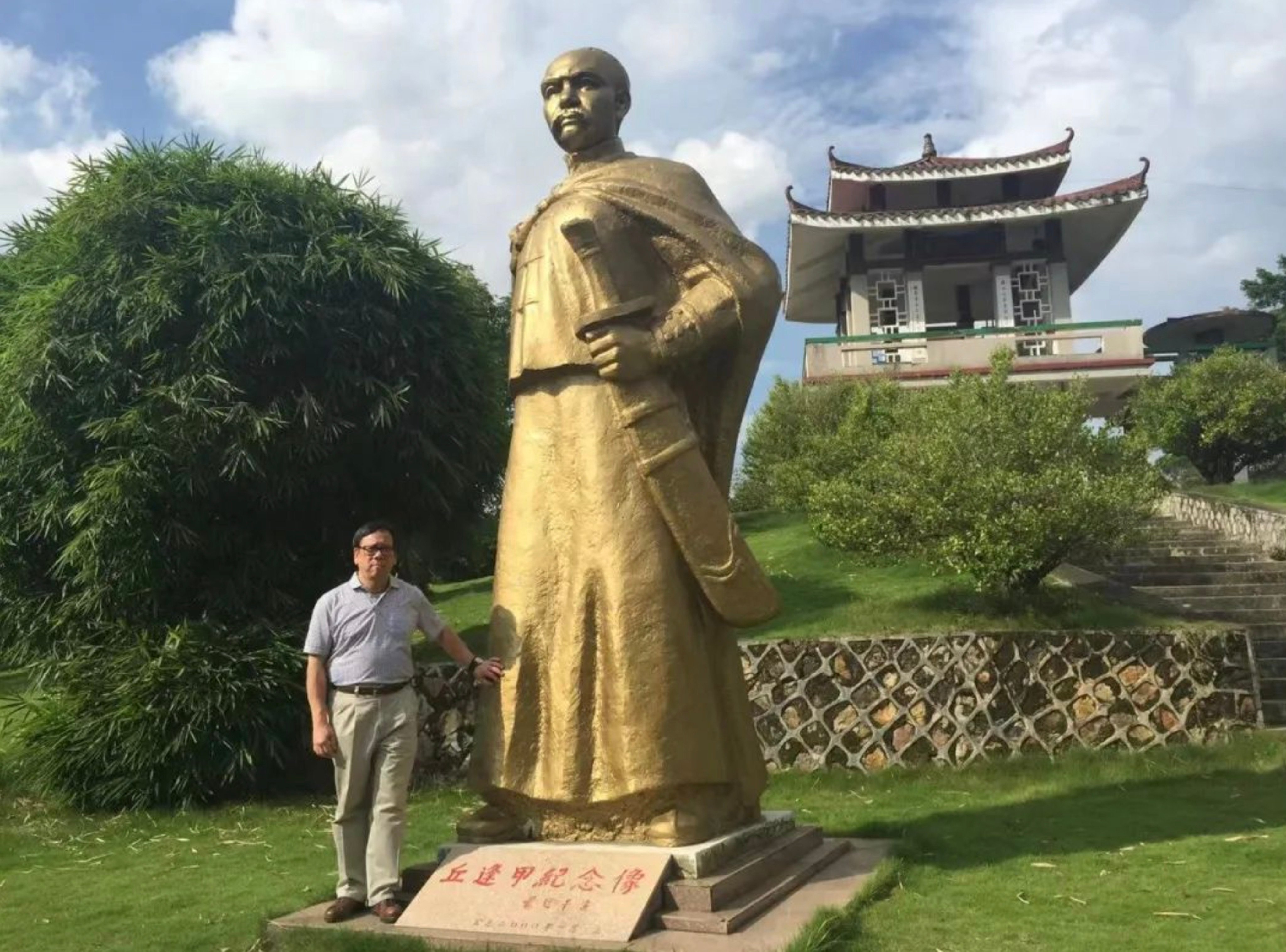 Algernon Yau at a statue of his grandfather, Qiu Fengjia. Photo: Weibo