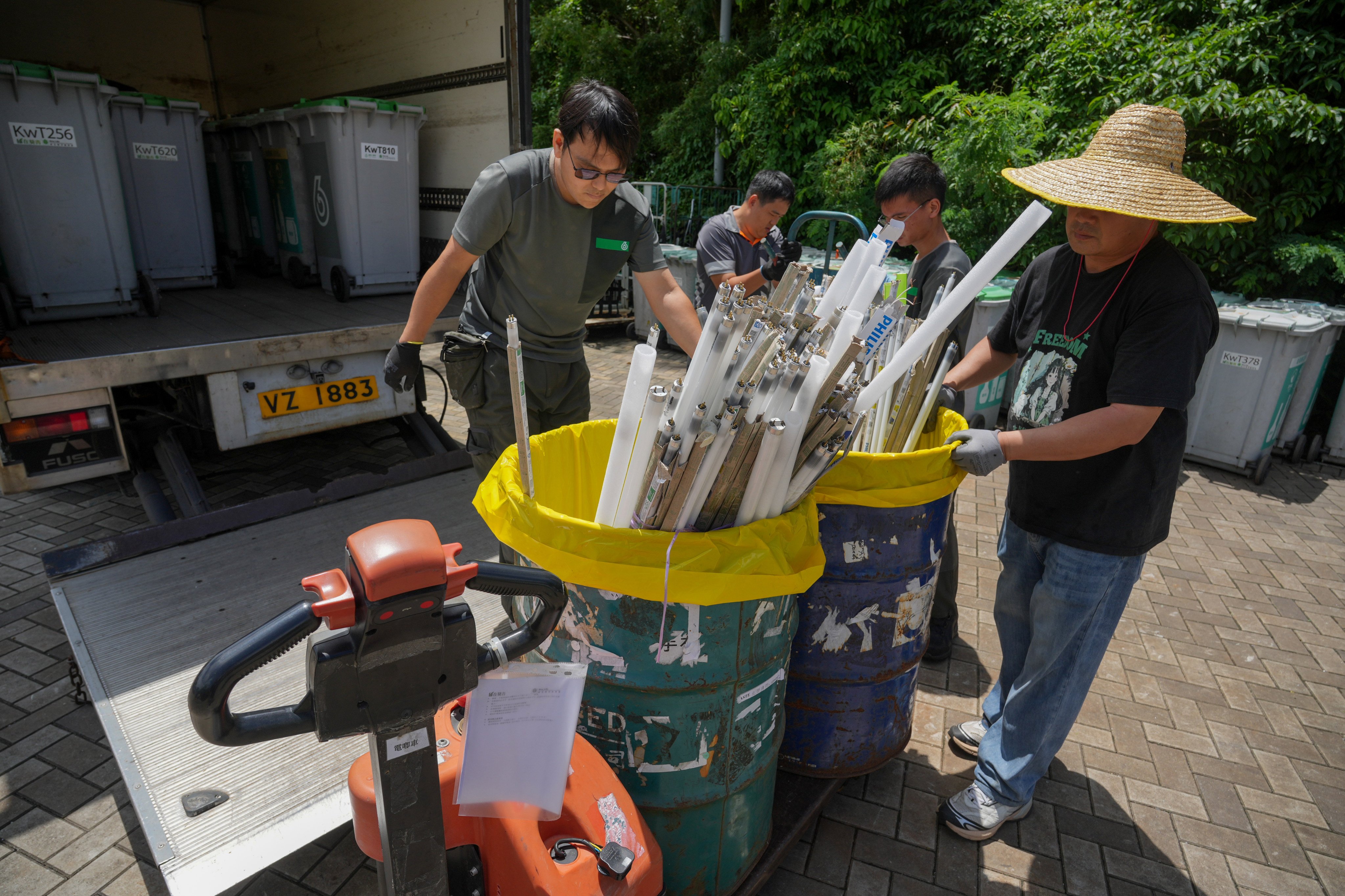 Workers collect discarded fluorescent tubes  at the Green@Kwai Tsing Recycling Station, located on Tam Kon Shan  Road in Tsing Yi on August 20. Photo: May Tse