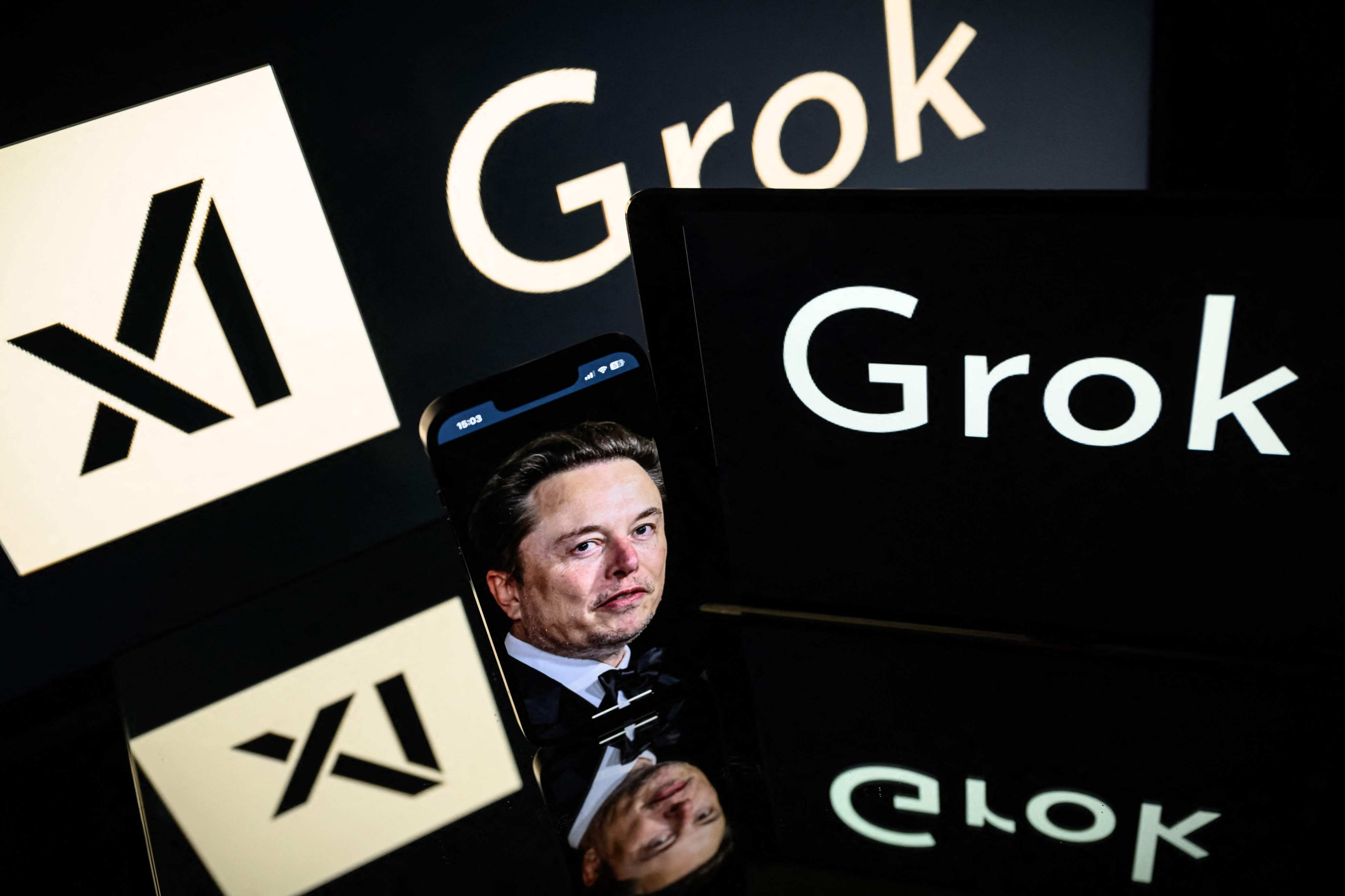 Screens display the logo of Grok, a generative artificial intelligence chatbot developed by Elon Musk’s xAI. Photo: AFP