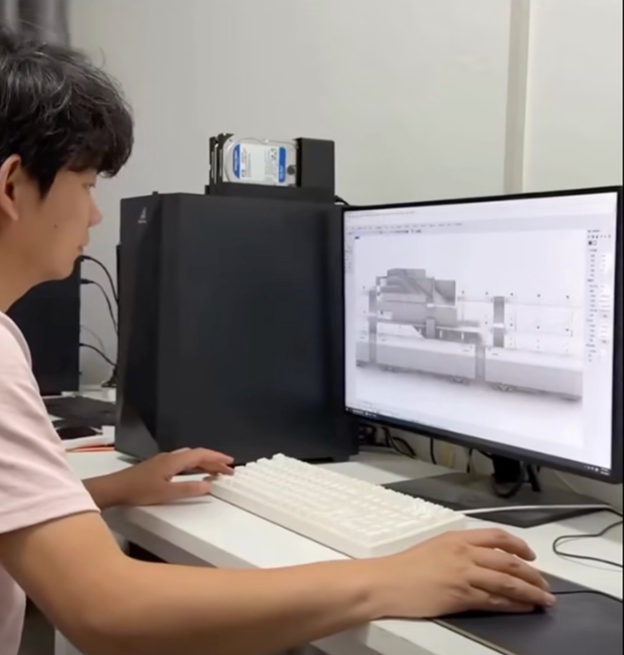 Self-taught Xing is hard at work on his computer. The influencer had to learn many skills to make his mini creations. Photo: Facebook