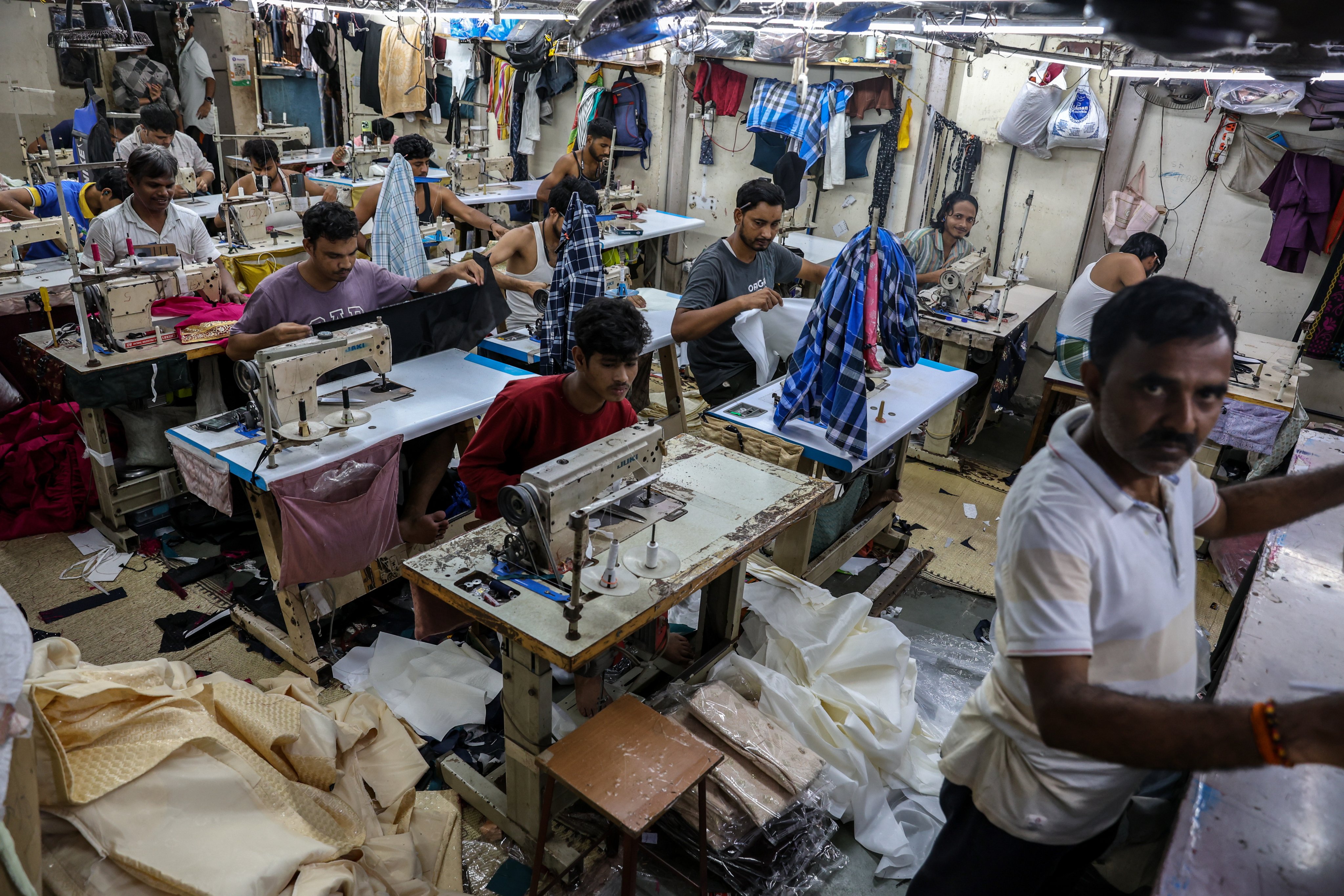 Indian labourers work at a textile workshop manufacturing garments in Mumbai, India, earlier this month. Photo:  EPA