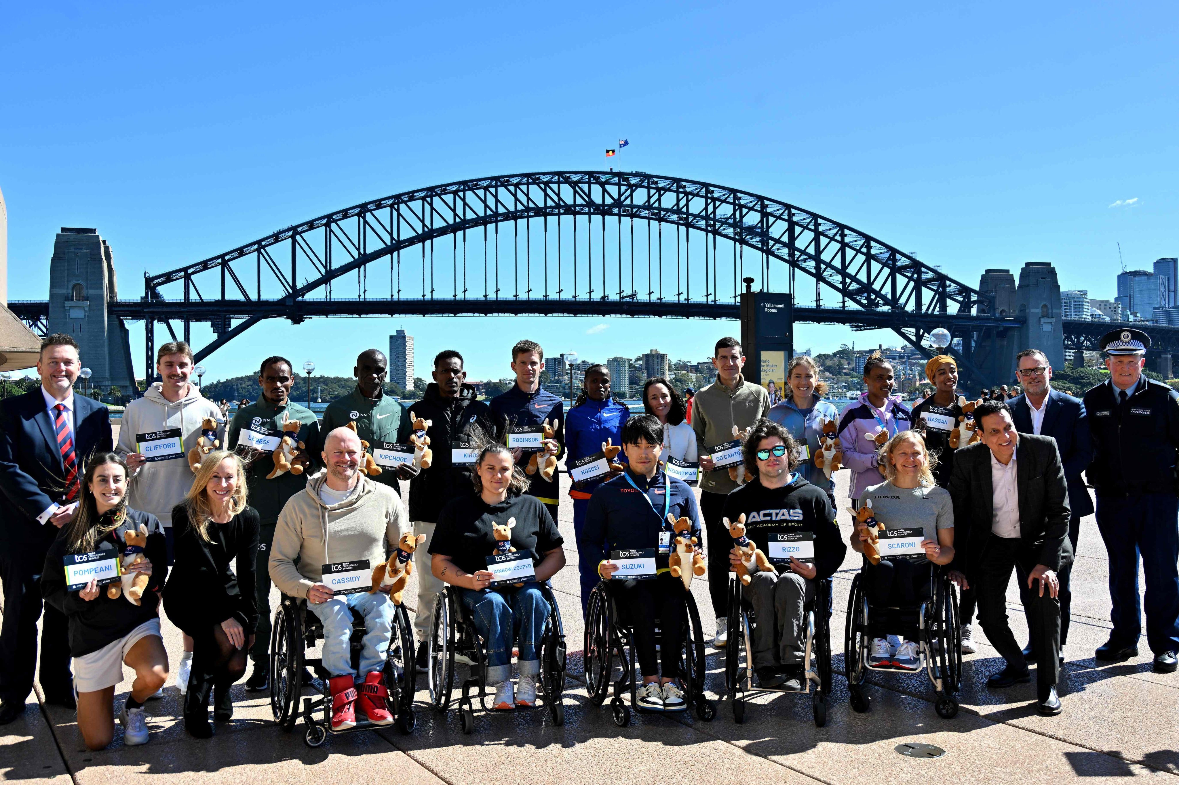Elite marathon runners pose for photos in front of the Sydney Harbour Bridge. Photo: AFP