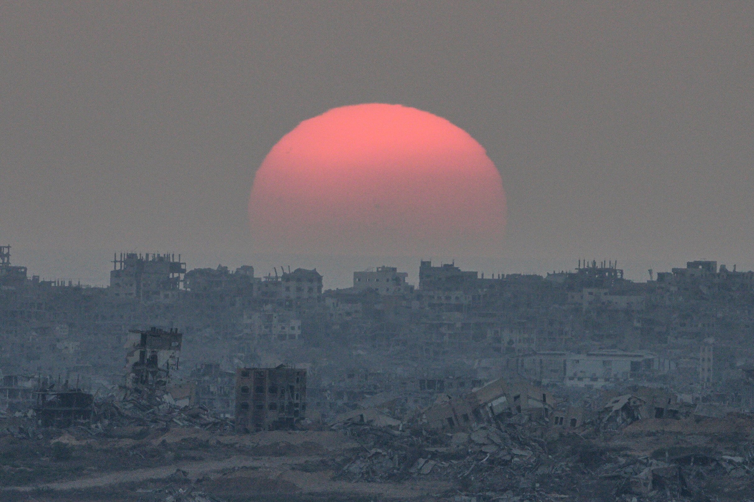 The sun sets behind buildings destroyed during Israeli ground and air operations in the Gaza Strip on Tuesday. Photo: AP