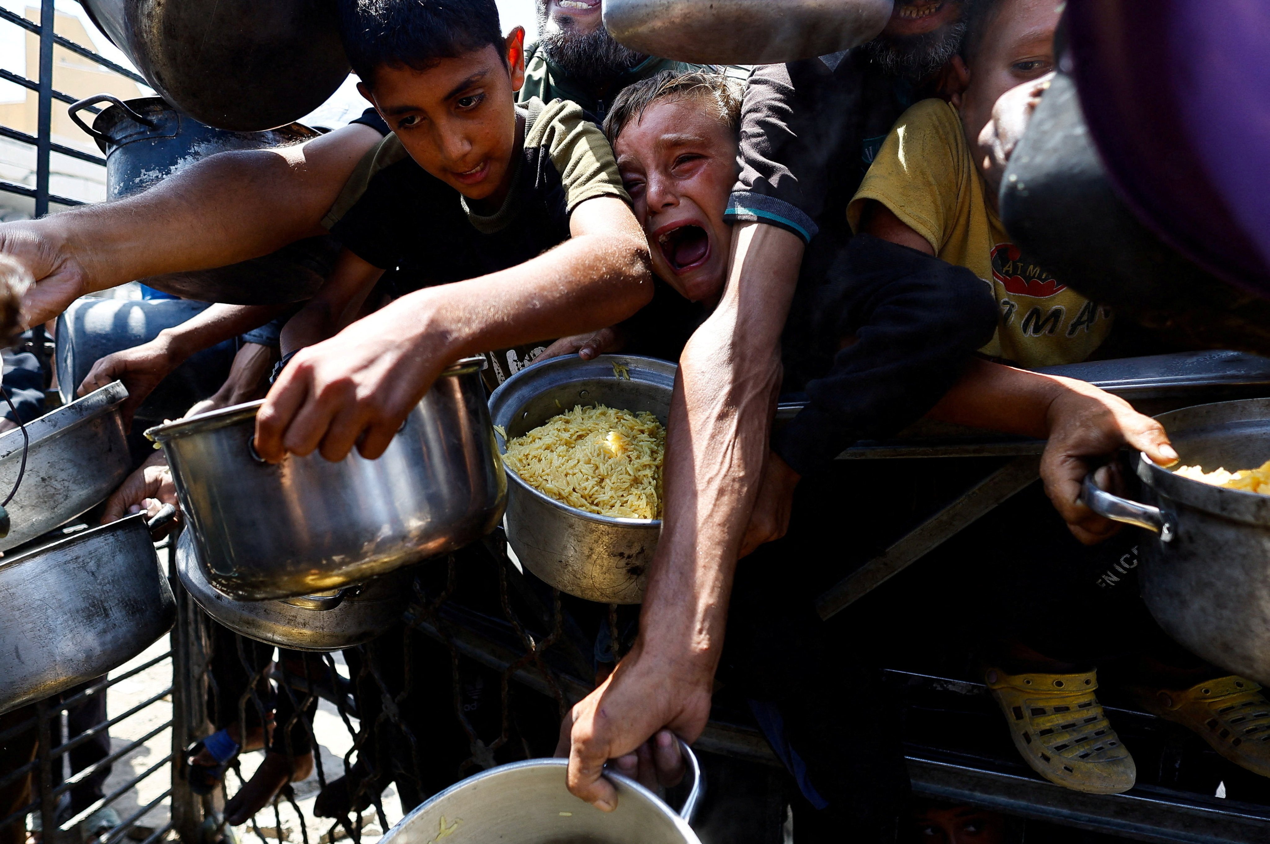 Palestinians wait to receive food from a charity kitchen in Gaza City. Photo: Reuters