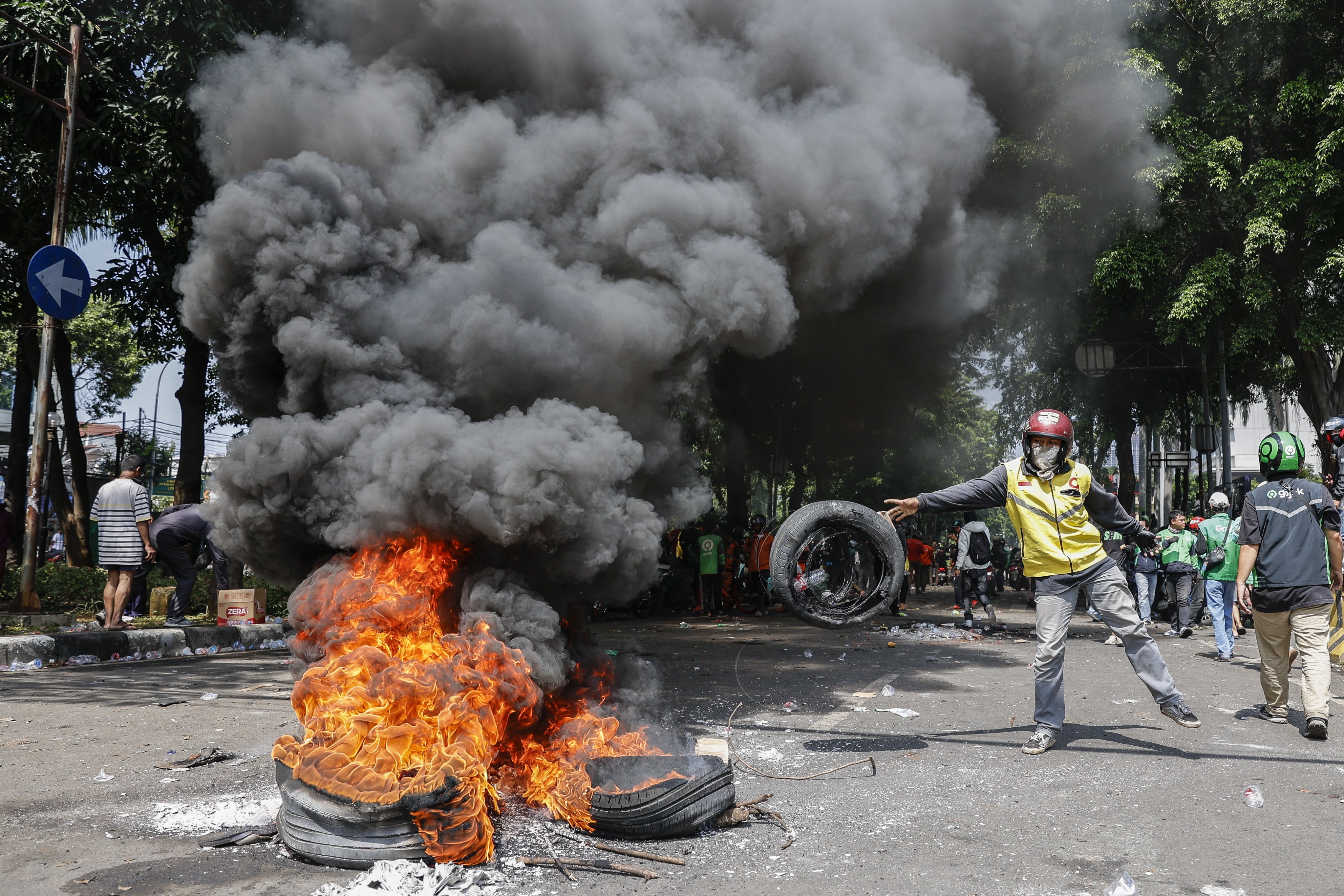 A protester burns tyres after clashing with police in Jakarta on Friday. Photo: EPA