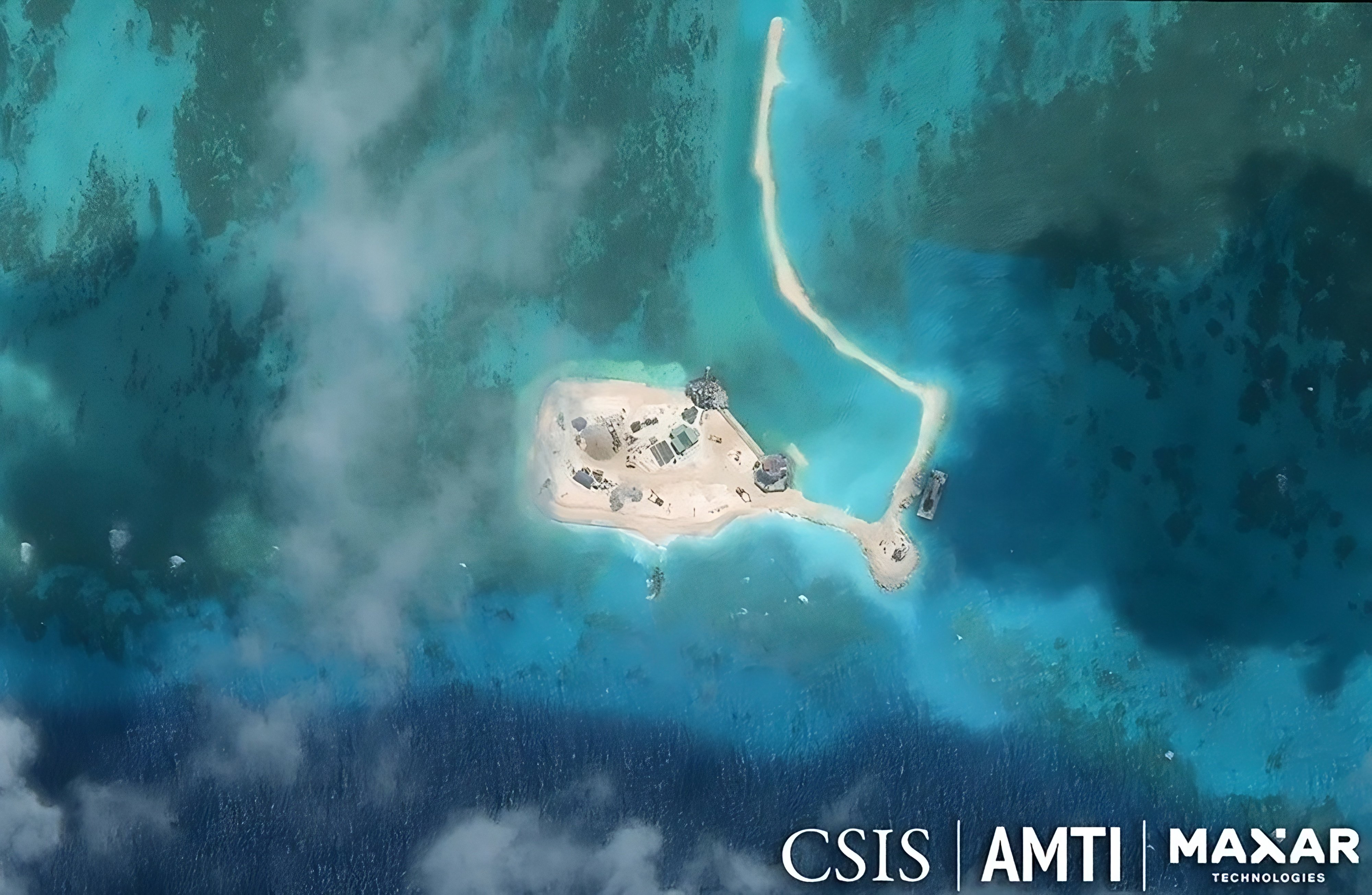 Satellite imagery taken in 2025 shows Vietnamese dredging and landfill work at a reef in the Spratly Islands that had previously housed only small concrete pillbox structures. Photo: Handout