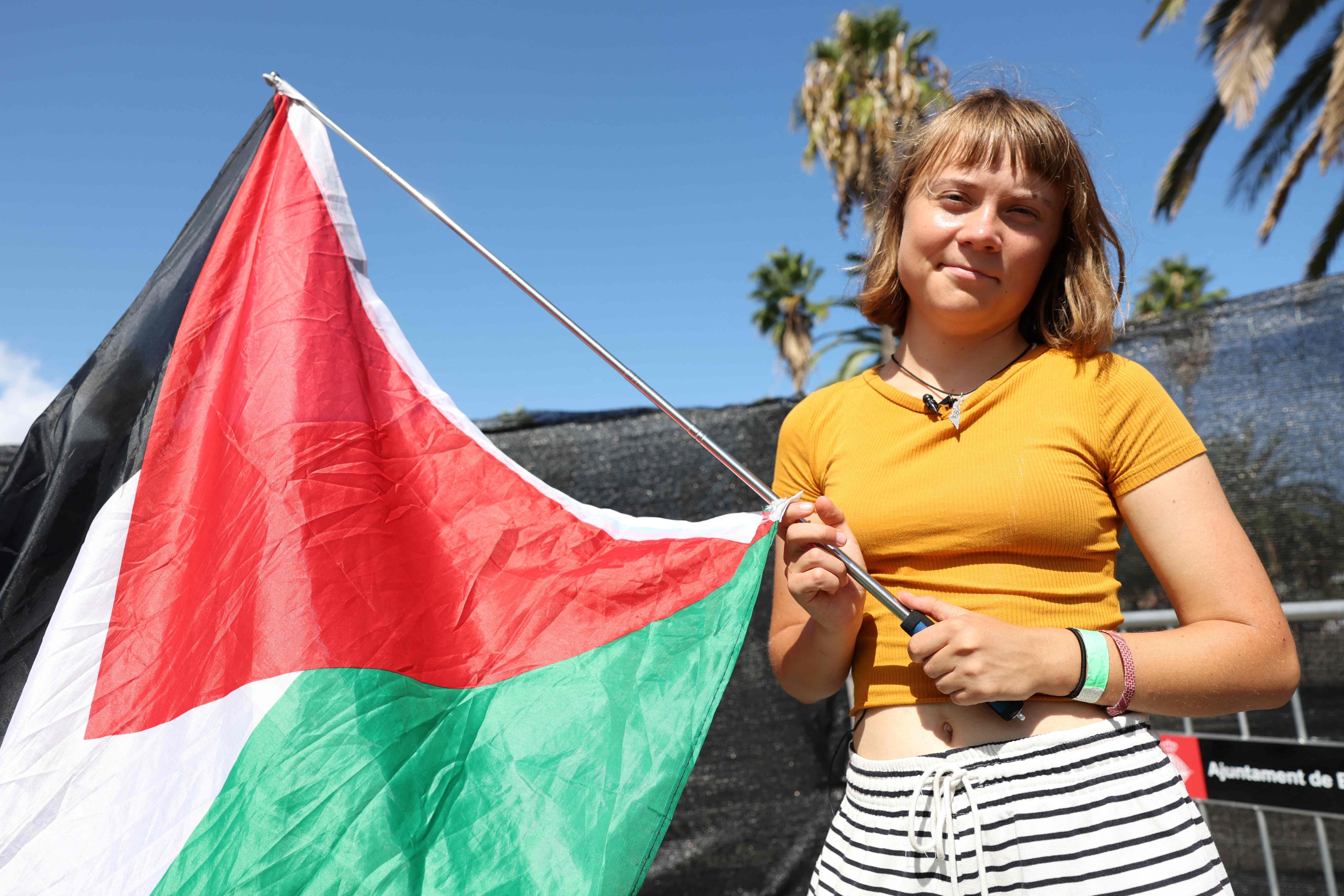 Swedish climate activist Greta Thunberg poses with a Palestinian flag as a flotilla carrying humanitarian aid and activists prepares to leave for Gaza, in Barcelona, Spain, on Saturday. Photo: AFP