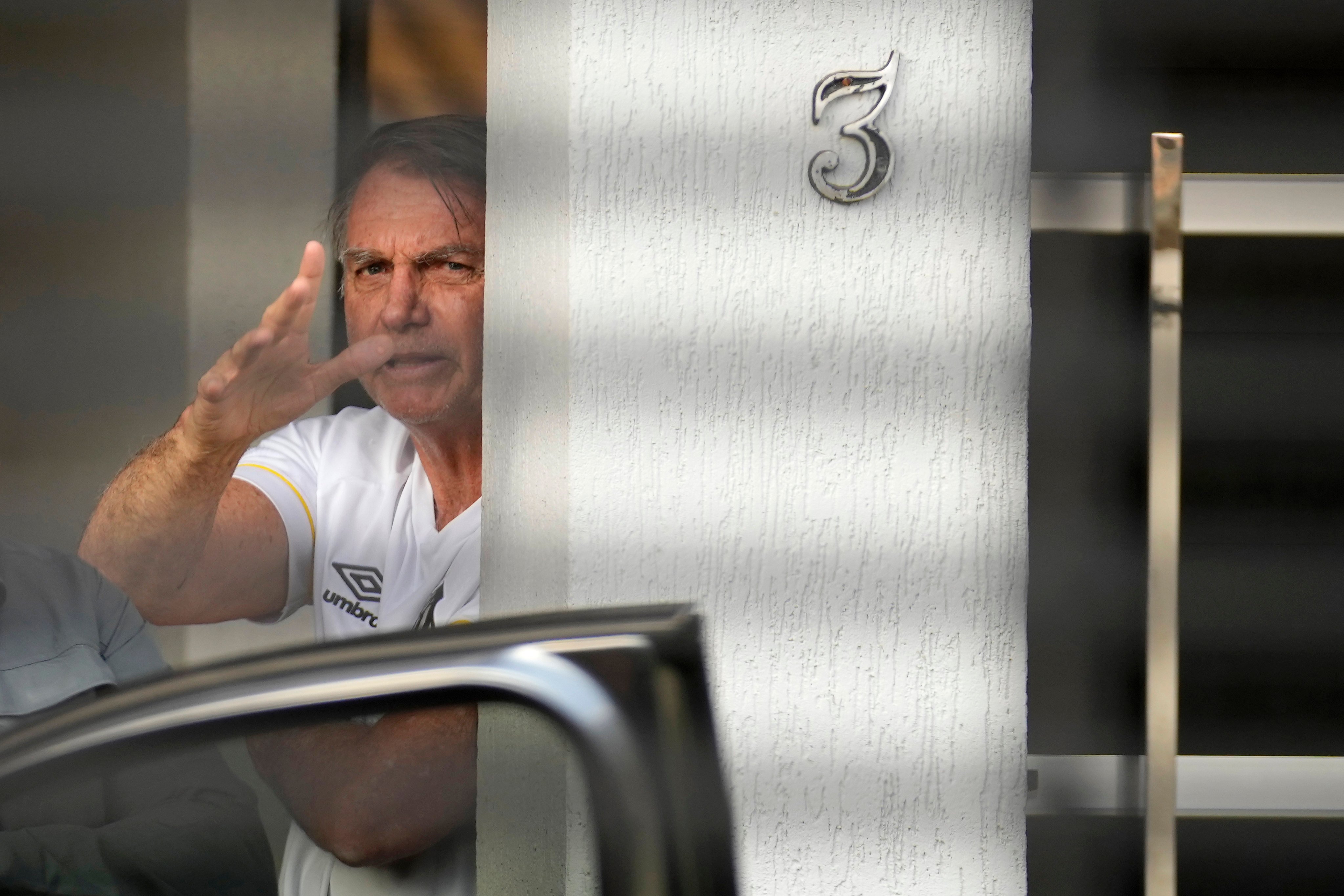 Brazil’s former president Jair Bolsonaro at the entrance to his home where he is under house arrest. Photo: AP