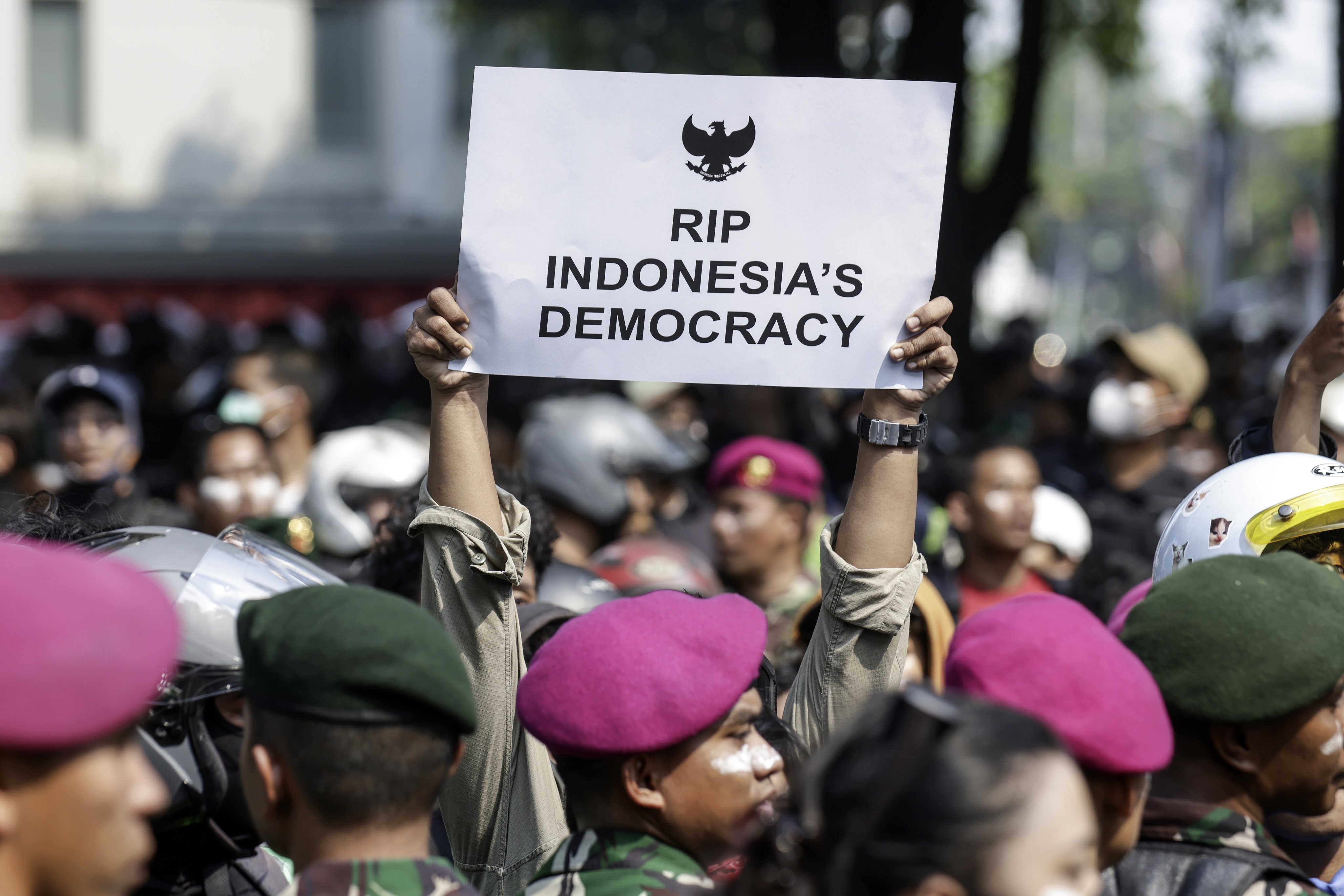 A protester holds up a placard during a protest outside the Mobile Brigade Police headquarters in Jakarta on August 29. Photo: EPA