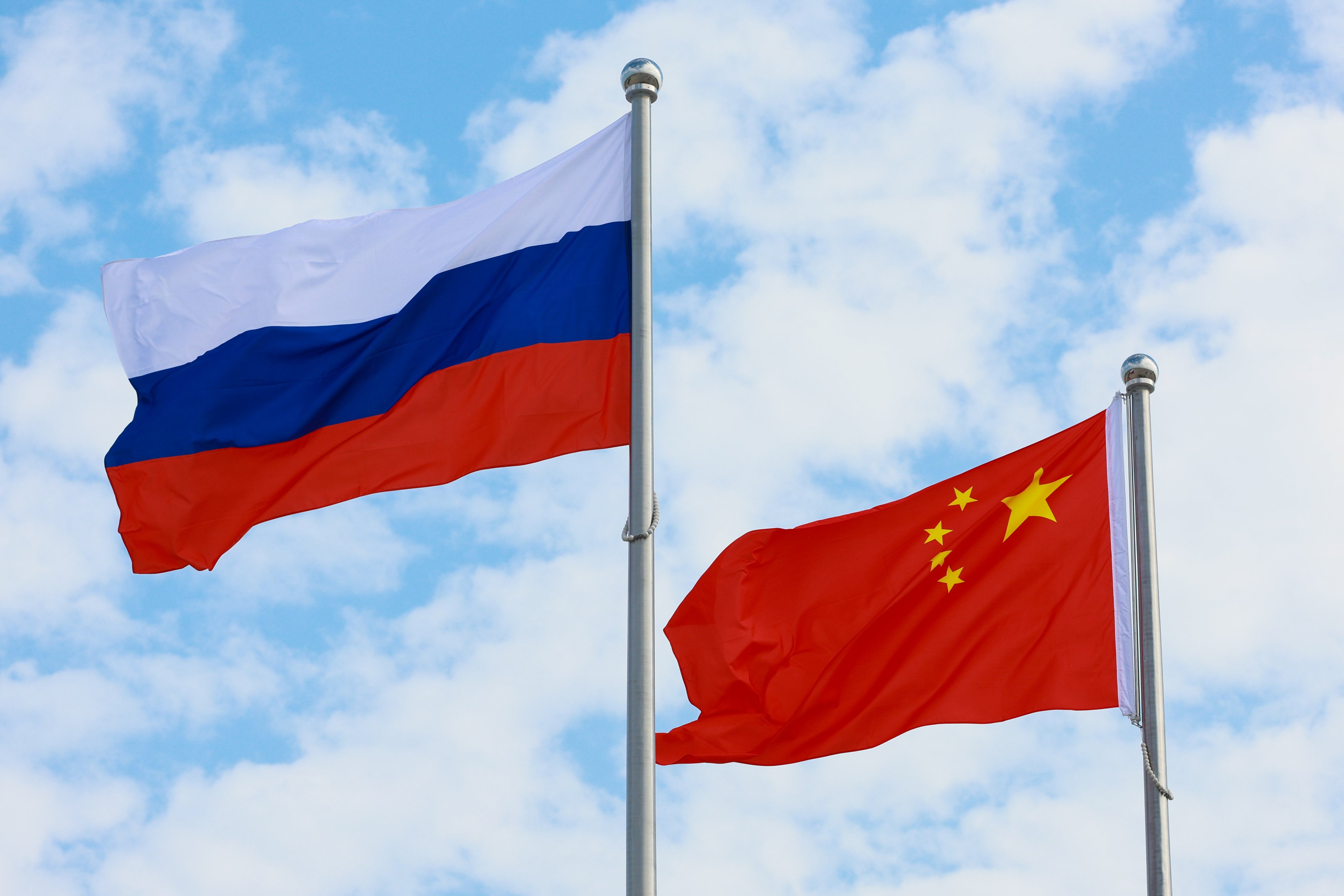 Russian and Chinese national flags fly ahead of a ceremony to welcome Vladimir Putin, President of Russia, at Tianjin Binhai International Airport, on August 31. Photo: dpa