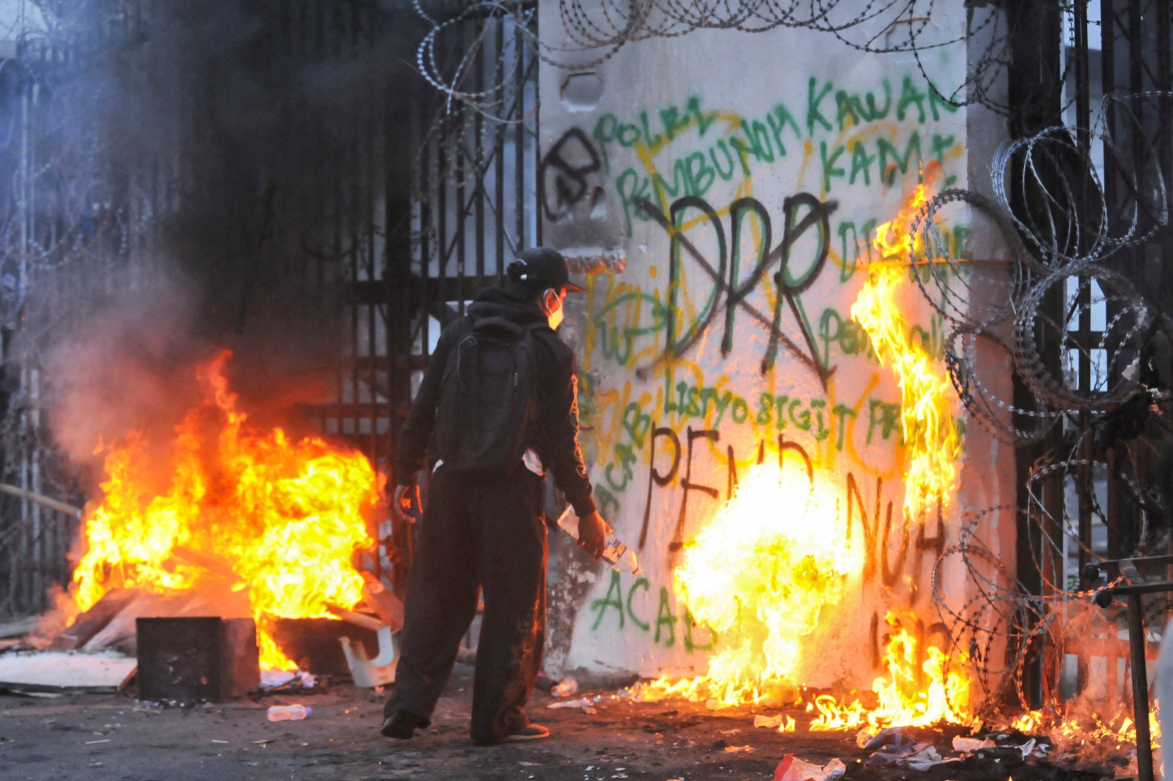 A protester sets fire to the gate of the regional parliament building in Bandung, Indonesia, on Monday. Photo: Reuters