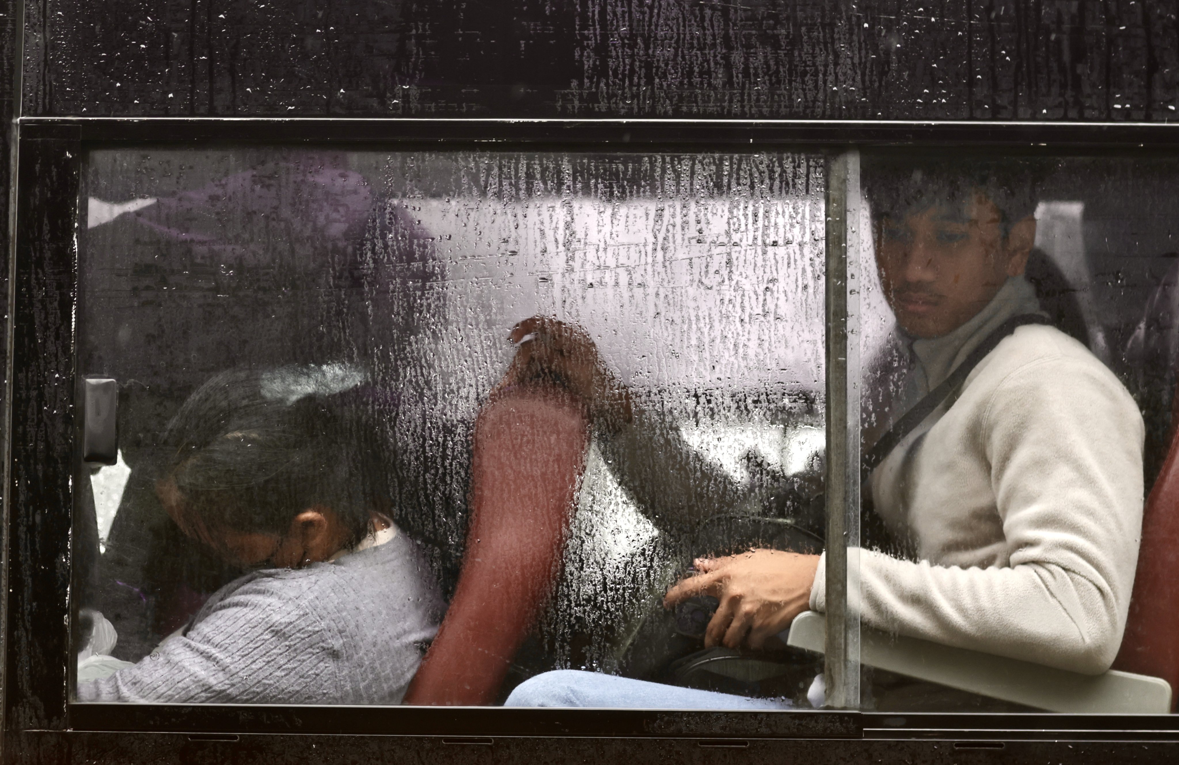 Passengers sit inside a bus during a downpour in Manila last month. Photo: EPA