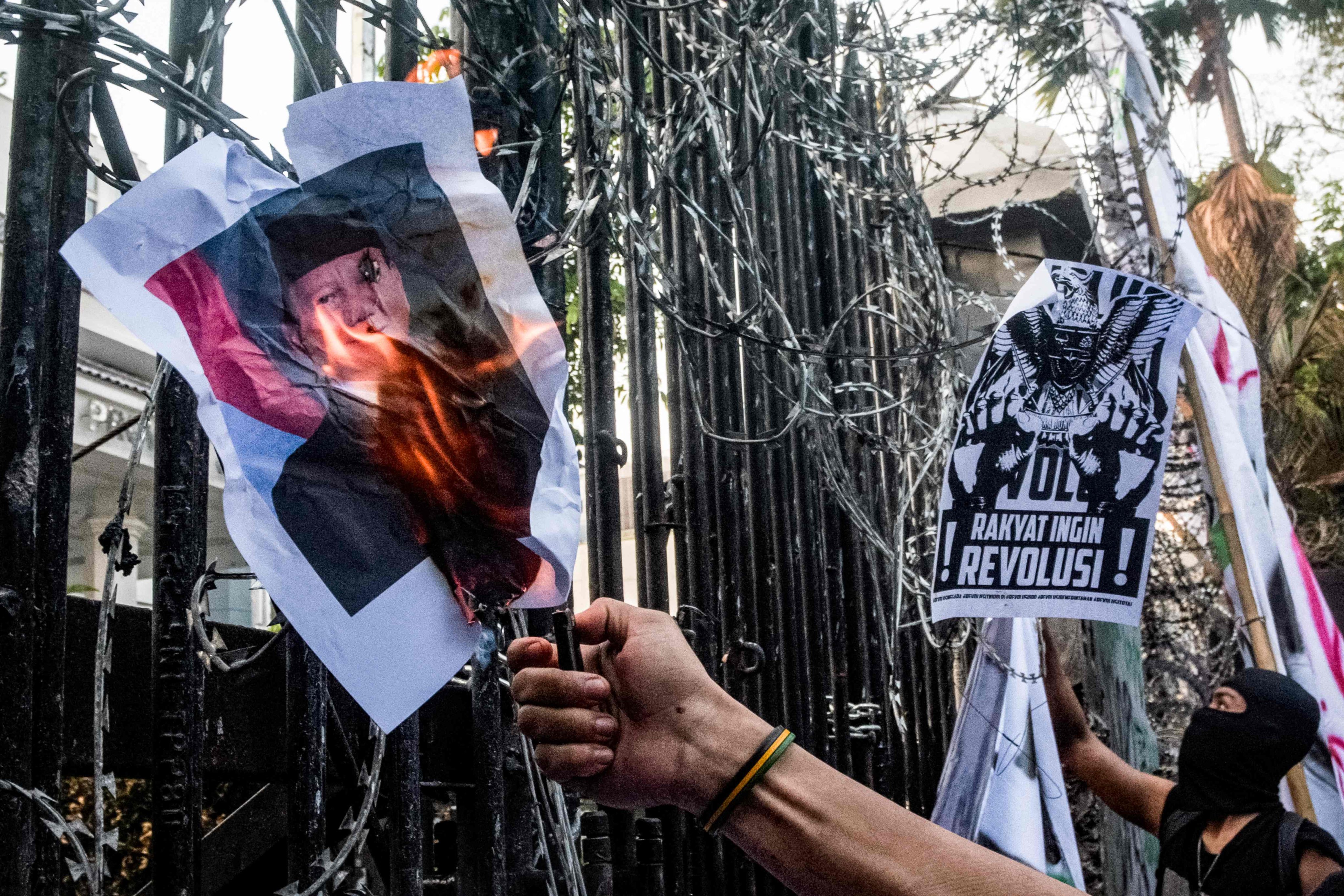 A demonstrator sets a picture of Indonesia’s President Prabowo Subianto on fire during a protest in Bandung, West Java, on Monday. Photo: AFP