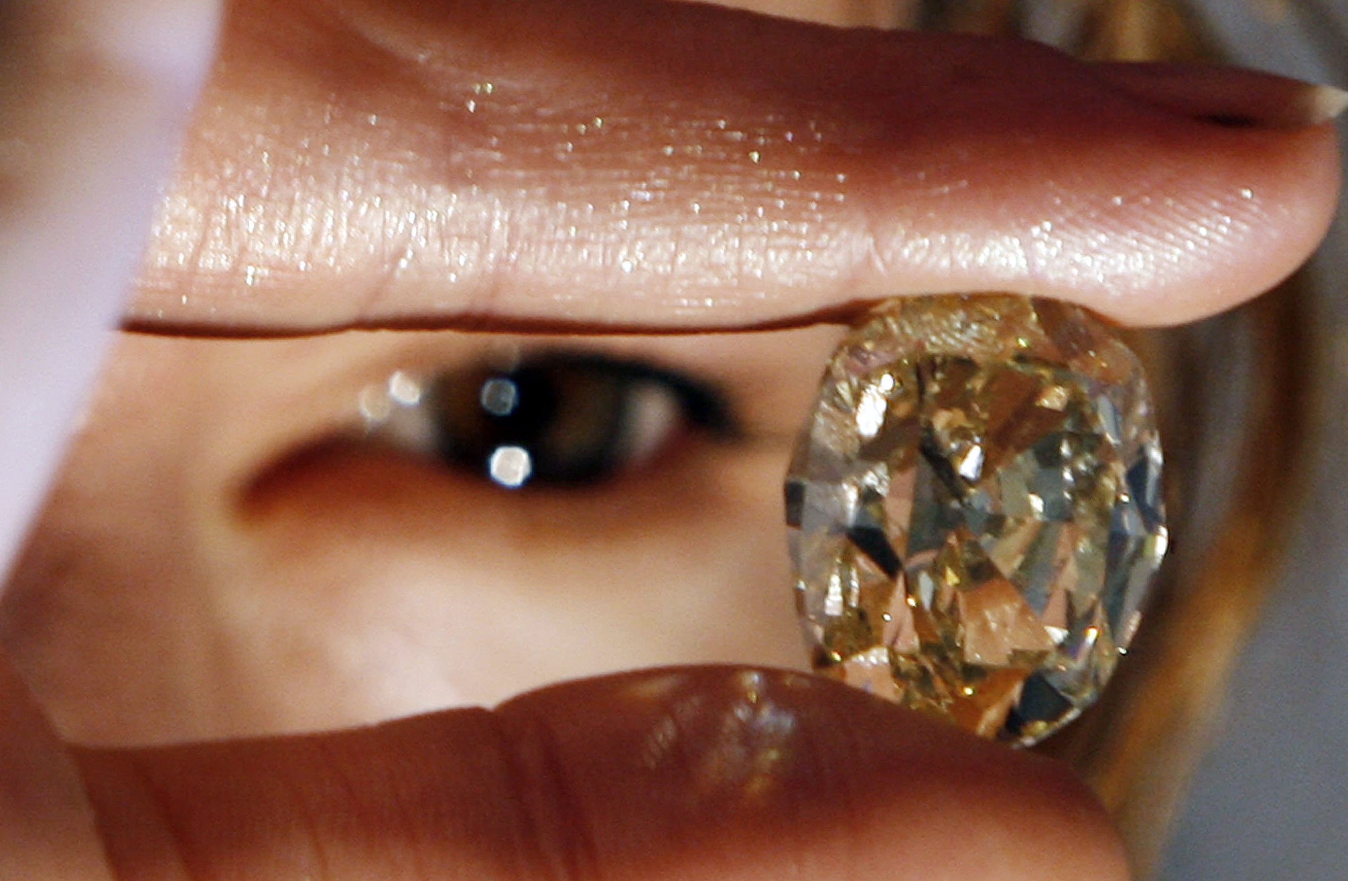 A model looks at a yellow 42.02 carat diamond at an auction show in Mumbai. Gem and jewellery exporters in India say they are seeing a sharp slowdown in new US orders due to a 50 per cent tariff on Indian exports. Photo: AFP