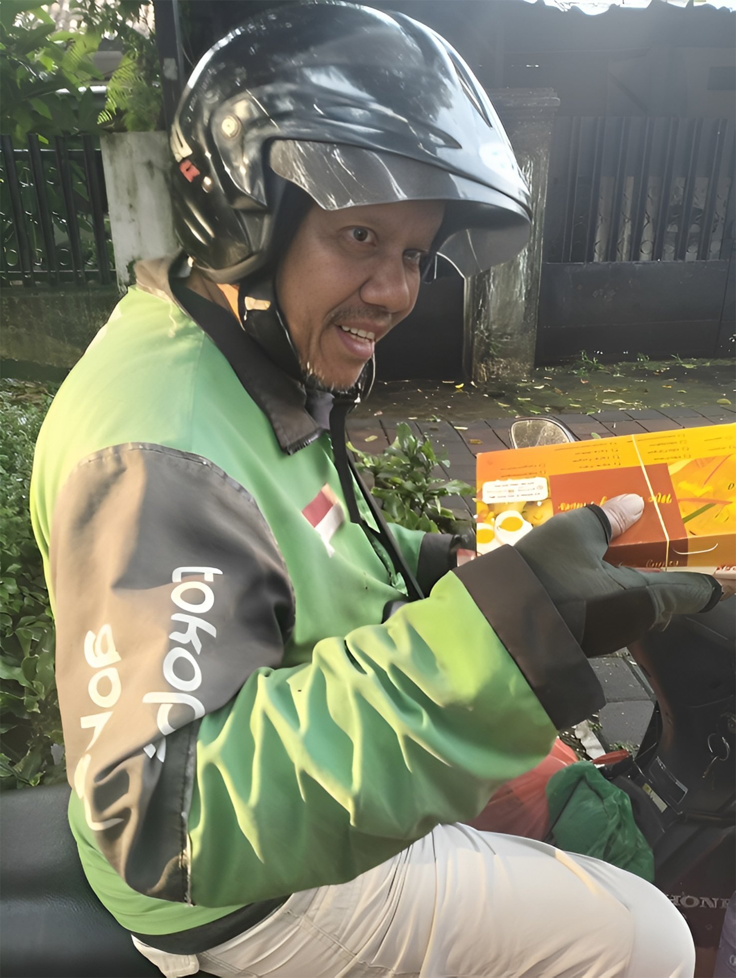 A Jakarta-based ride-hailing motorbike rider receives a food parcel donated by a Malaysian well-wisher. Photo: Threads/Shamin Azim Khan