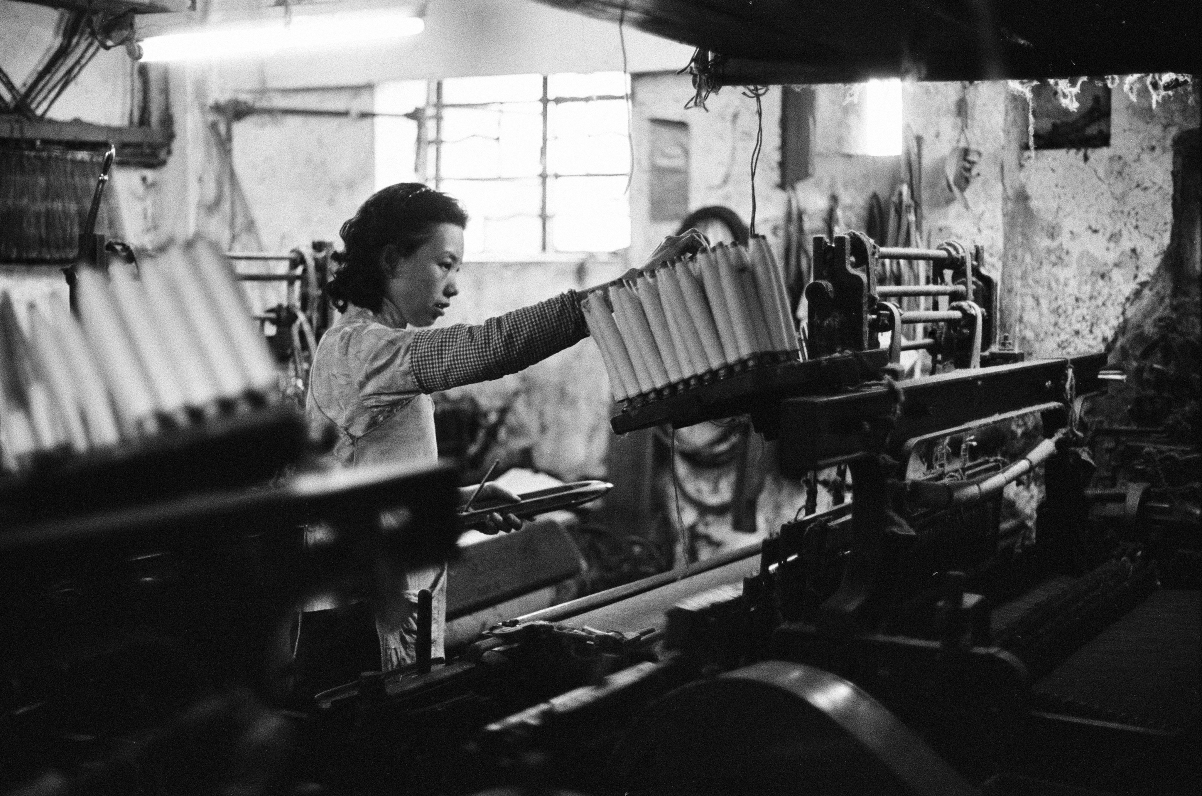 A worker at the loom of a one-room factory in the basement of a tenement building in Hong Kong during the 1960s. Photo: Getty Images