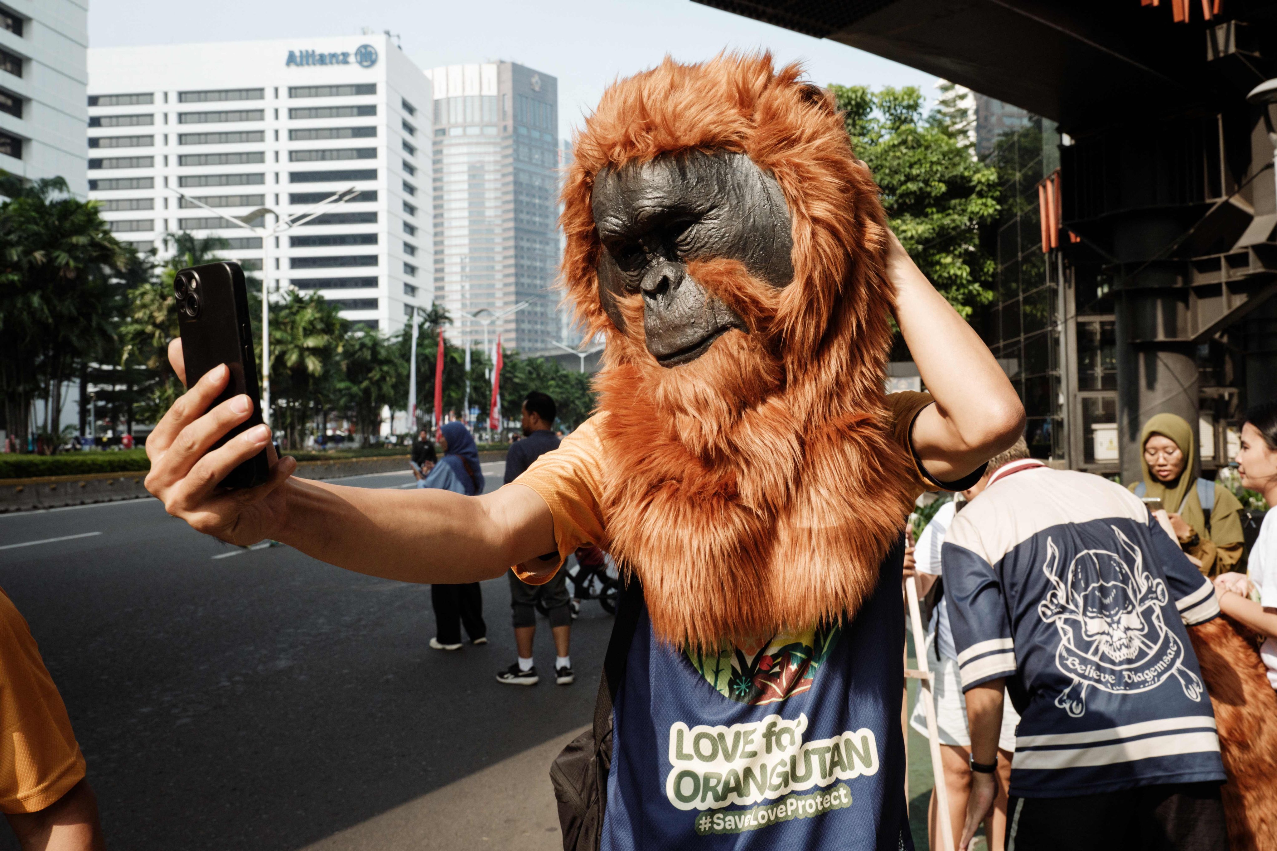 A man takes selfies while wearing an orangutan head as he attends an awareness action calling for the protection of orangutans to mark World Orangutan Day, observed on August 19. Photo: AFP