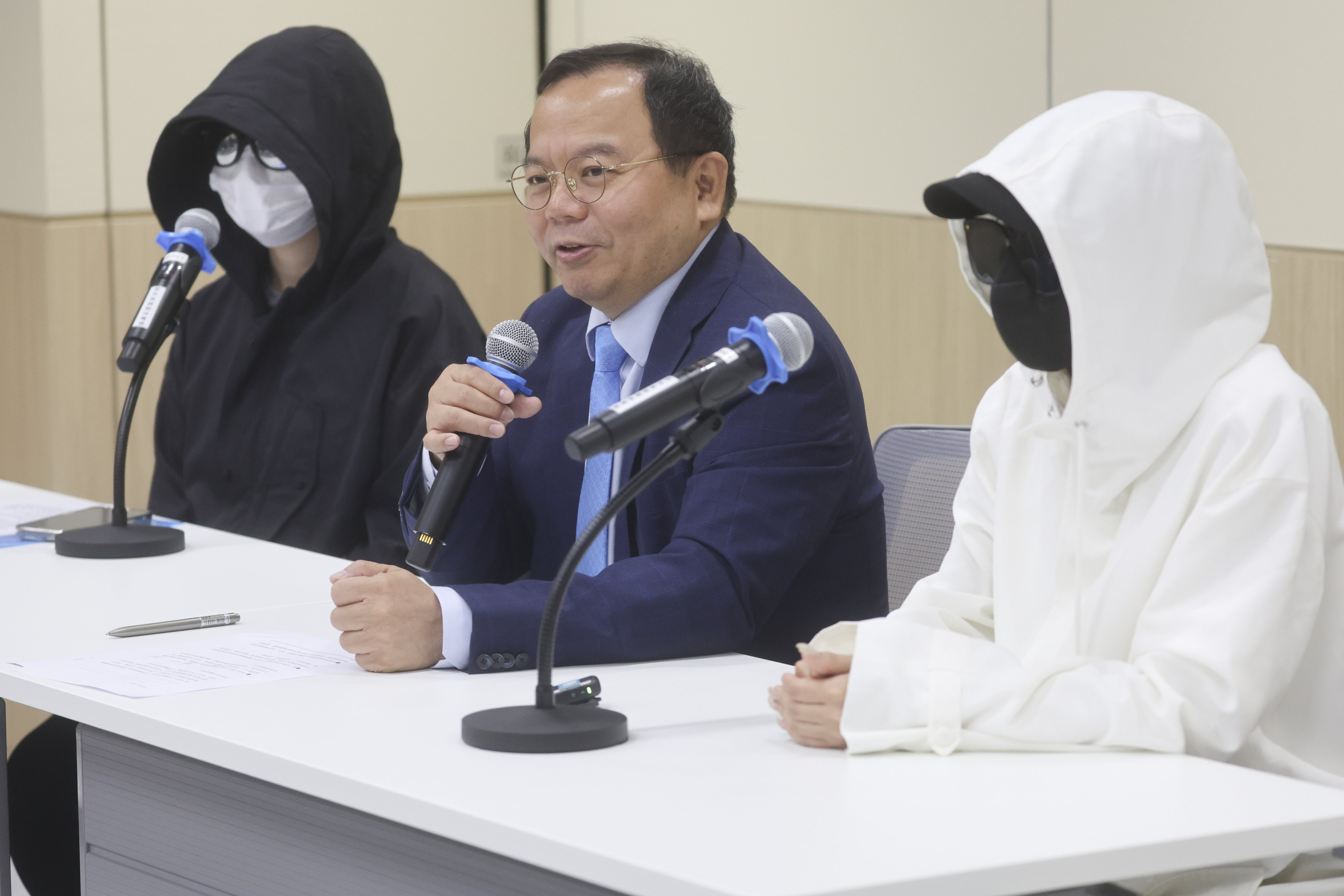 Chan Wing-Kwong (centre) and two anonymous residents who raised concerns about unlicensed medical practices speak at a media event on Friday. Photo: Edmond So